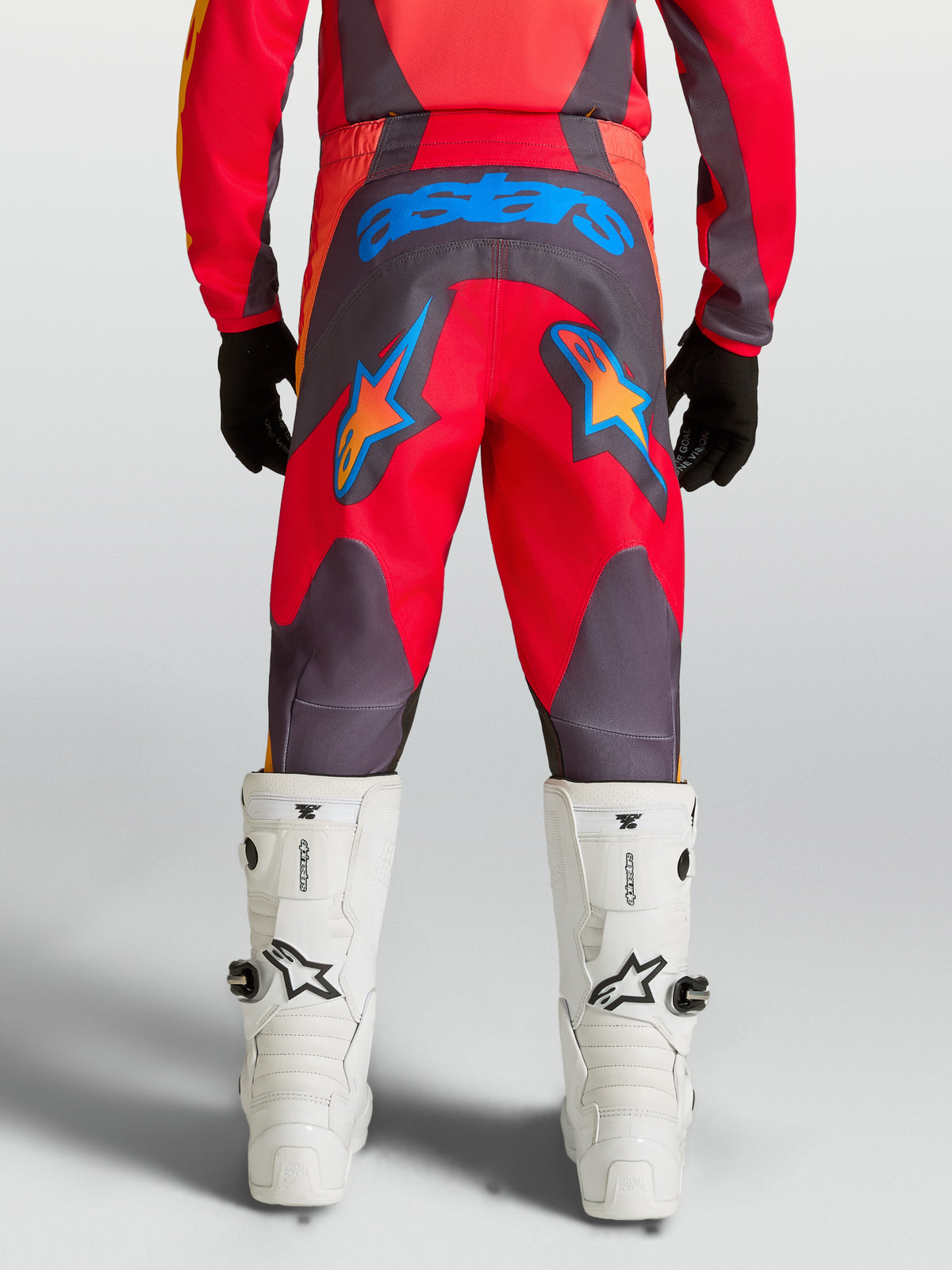 Alpinestars Pantalons Fluid Hunt Junior, équipement de motocross pour enfant, rouges et gris avec étoiles bleues, assise renforcée en polyfibre 600D, vus de dos