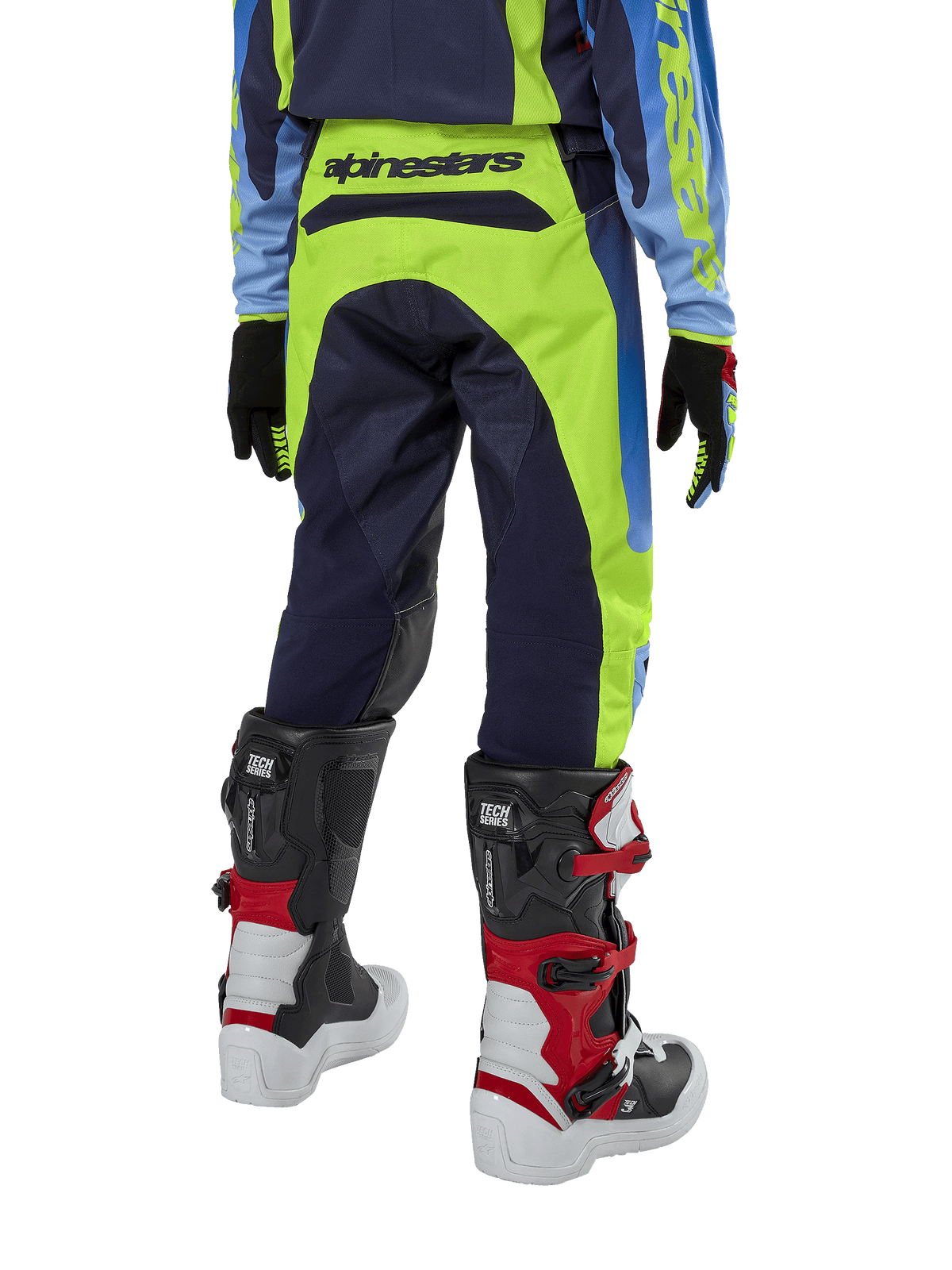 Pantalon Alpinestars Racer Hoen Junior 2024, pantalon de motocross, jaune fluo et bleu marine Night Navy, vue arrière montrant le logo Alpinestars sur la ceinture, porté avec des bottes Tech Series noires et rouges et un maillot assorti, coupe sportive durable pour la conduite tout-terrain des jeunes