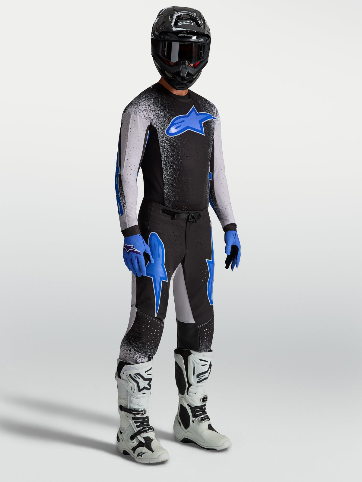 Alpinestars Maillot et Ensemble Supertech Hiten AFD, équipement de motocross noir et bleu pour homme avec bottes de course blanches.
