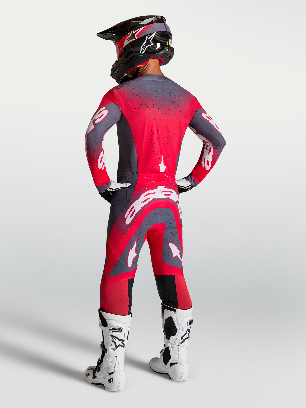 Maillot et ensemble Alpinestars Supertech Hiten AFD, tenue de motocross rouge fluo et gris, vue de dos sur mannequin.