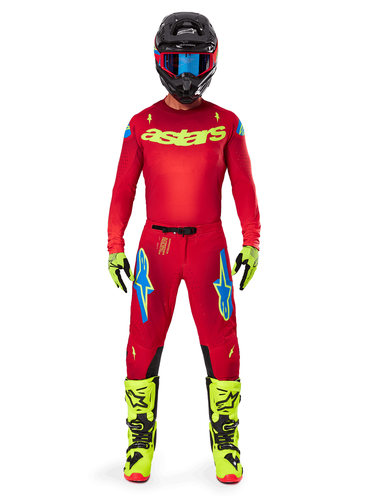 Pilote de motocross portant l'ensemble d'équipement complet Alpinestars 2025 Supertech Maker, maillot rouge vif avec logo 'astars' jaune fluo, pantalon rouge assorti avec accents bleus, casque noir avec lunettes bleues, bottes et gants jaune fluo, tenue coordonnée pour la course tout-terrain