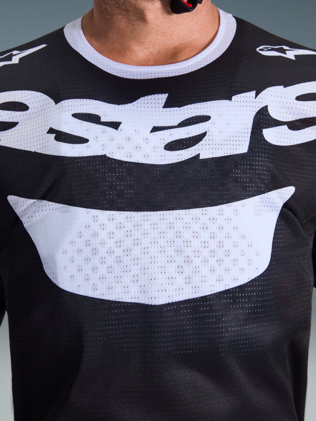 Maillot Alpinestars 2026 Racer Air Riway, maillot de motocross, noir et blanc, gros plan sur la poitrine montrant un grand graphique blanc et une construction en mesh respirant, col blanc et logos sur les épaules