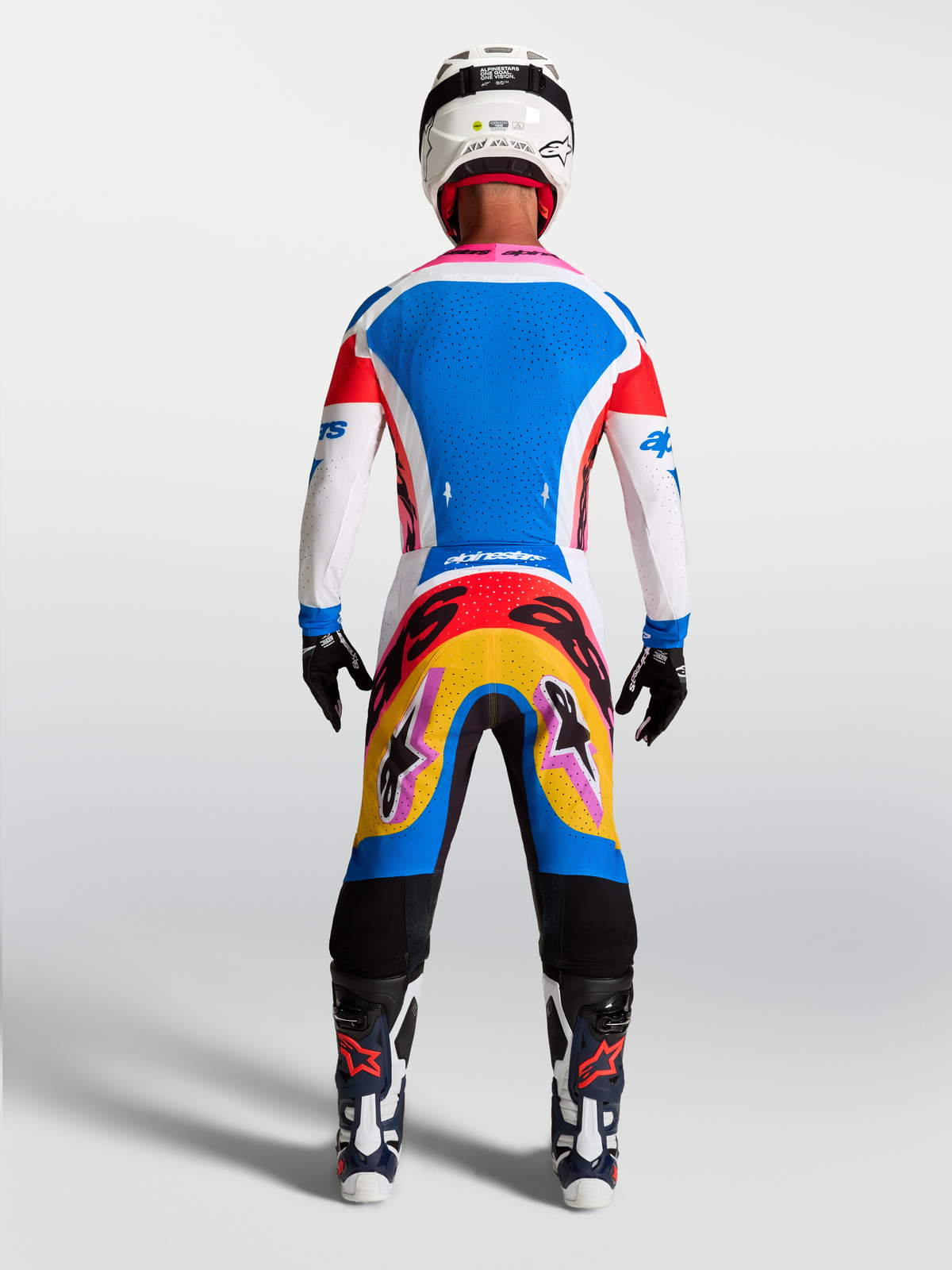 Alpinestars maillot Supertech Dyna et ensemble motocross, bleu et blanc avec accents roses, vue de dos sur mannequin