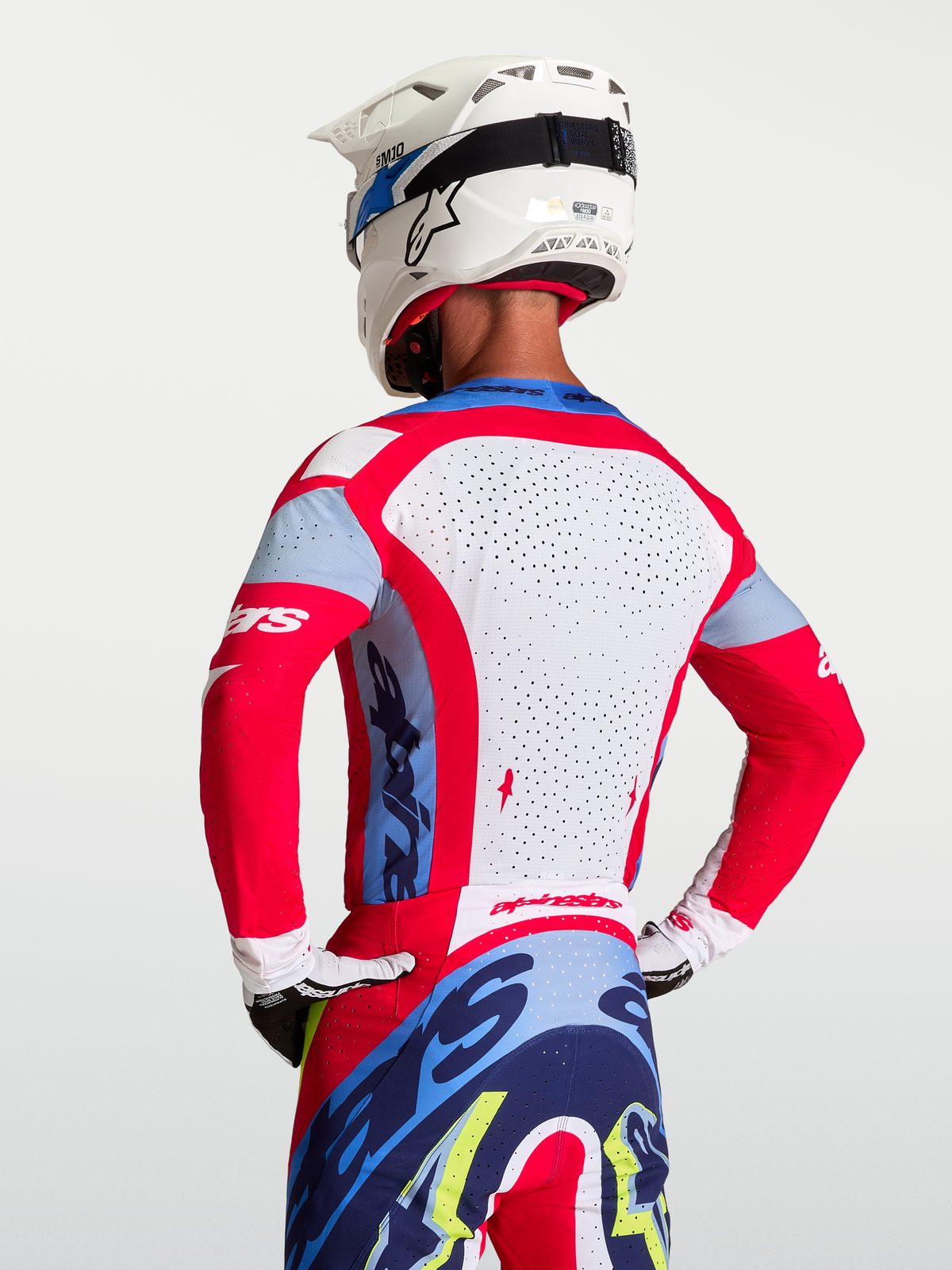 Maillot Supertech Dyna Alpinestars, maillot de course motocross pour homme, rouge et blanc, doté d'un panneau arrière en maille perforée respirante, vue de dos portée par un pilote.