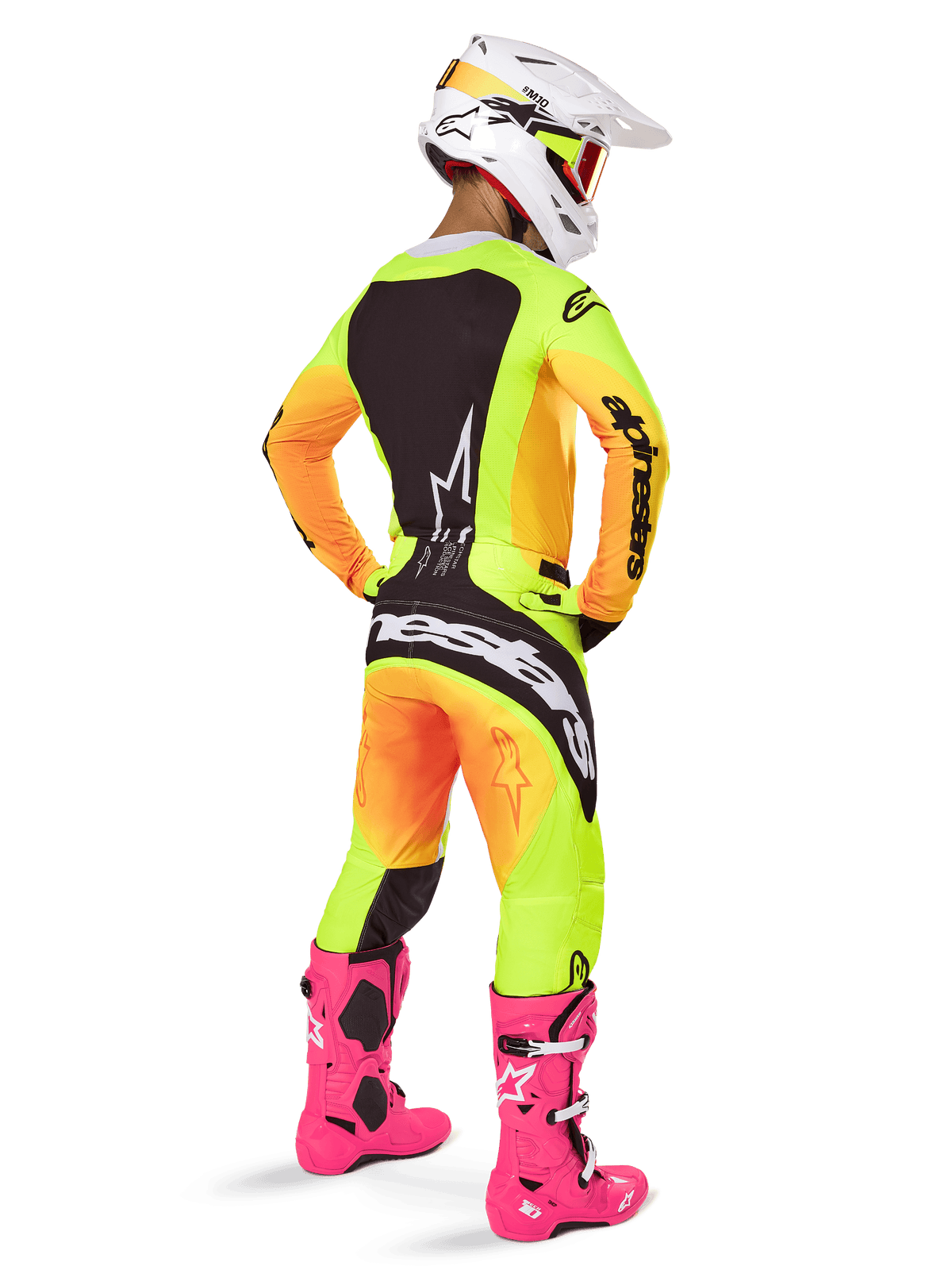 Pilote de motocross vu de dos, portant le maillot Alpinestars Techstar Melt 2025, dégradé jaune et orange vif avec sections noires, pantalon de motocross assorti, bottes rose vif et casque blanc, coupe athlétique pour la compétition tout-terrain