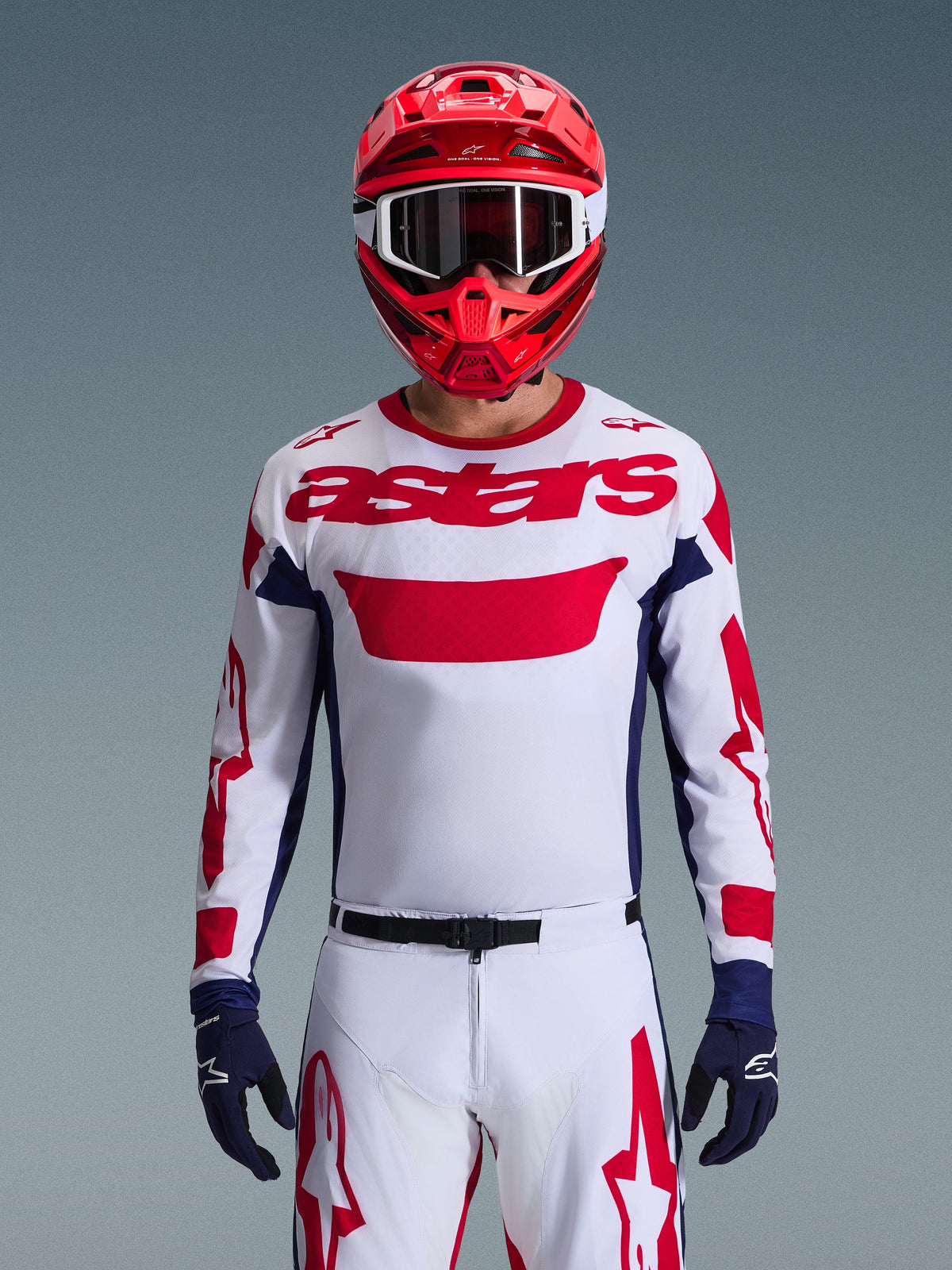 Alpinestars 2026 Racer Riway Gear Set, Motocross rider wearing white jersey with red branding and navy blue accents, matching white pants with red graphics, red helmet with white goggles, navy blue gloves, coordinated professional off-road racing outfit.