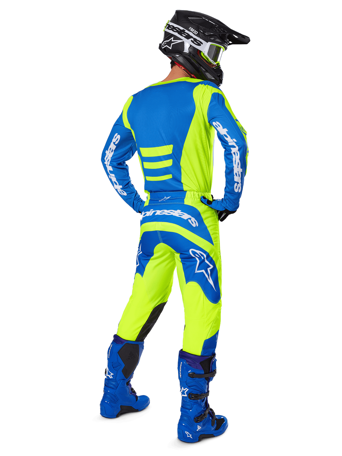 Pilote de motocross vu de dos portant l'ensemble d'équipement Alpinestars 2025 Fluid Haul en jaune fluo et bleu, composé d'un maillot bleu avec des touches jaunes, d'un pantalon jaune avec des empiècements bleus sur l'assise et les genoux, de bottes bleu vif et d'un casque noir.