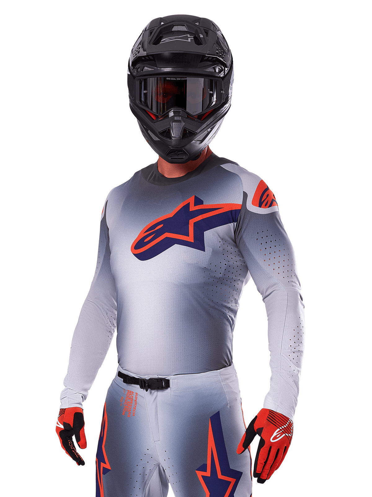Motocross rider wearing Alpinestars 2025 Supertech Lipan Gear Set, Gray jersey and pants with navy and orange accents, matte black helmet with goggles, and red and black gloves, athletic performance gear for off-road racing