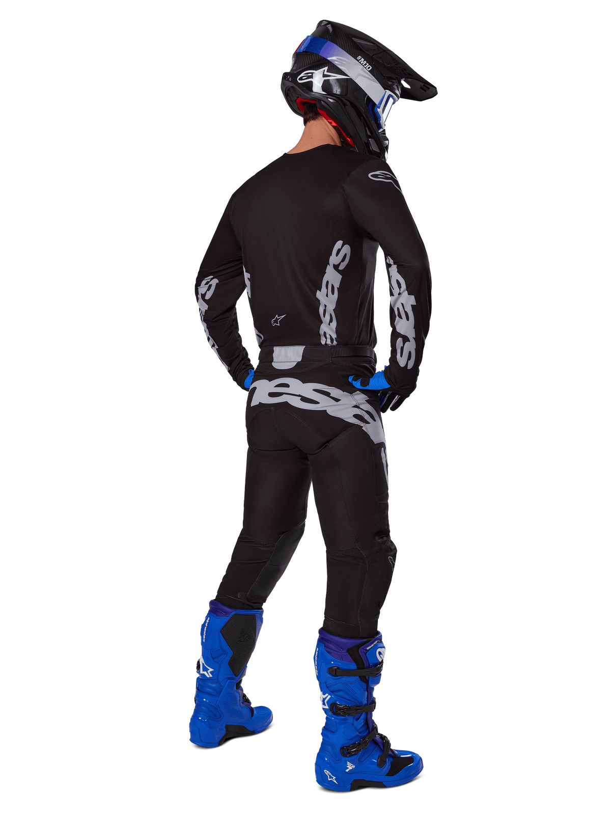 Motocross rider from a rear view wearing the Alpinestars 2025 Racer Graphite Gear Set, Black and Gray jersey and pants with gray branding, paired with bright blue motocross boots, a black and blue helmet, and blue gloves, complete performance off-road outfit.