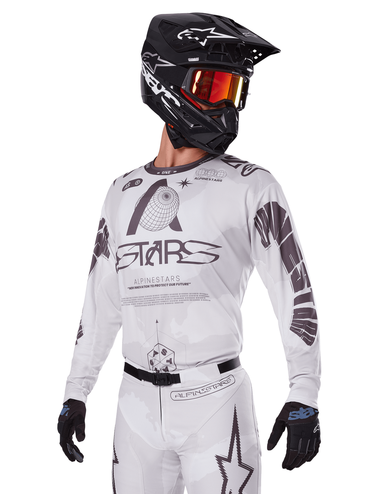 Ensemble d'équipement Alpinestars Racer Hollow 2025, maillot et pantalon de motocross, blanc avec des graphismes noirs et gris, arborant le marquage 'ASTARS' et des motifs de globe ajouré, porté avec un casque noir, des lunettes à effet miroir rouge et des gants noirs, conçu pour la performance tout-terrain