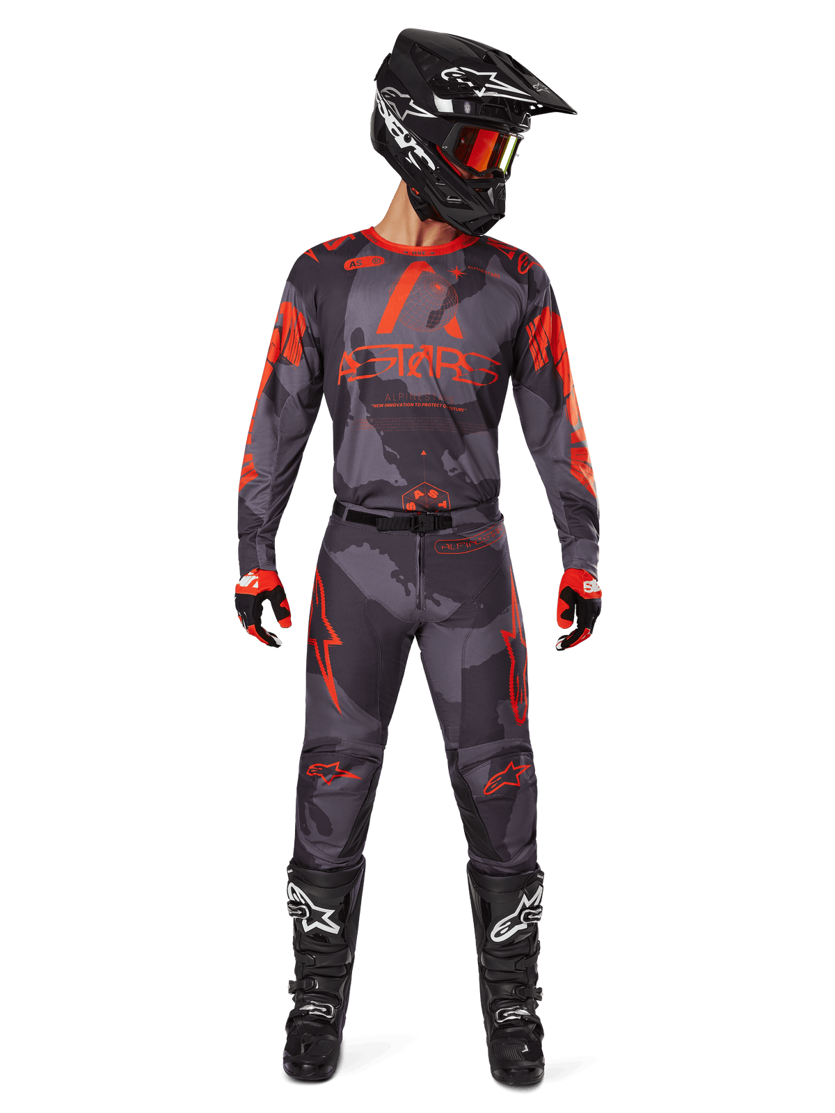 Motocross rider wearing Alpinestars 2025 Racer Hollow Jersey and matching pants in Gray Camo Orange Fluo, complete gear set with black helmet, goggles, gloves, and boots, featuring bold orange logos and camo pattern.