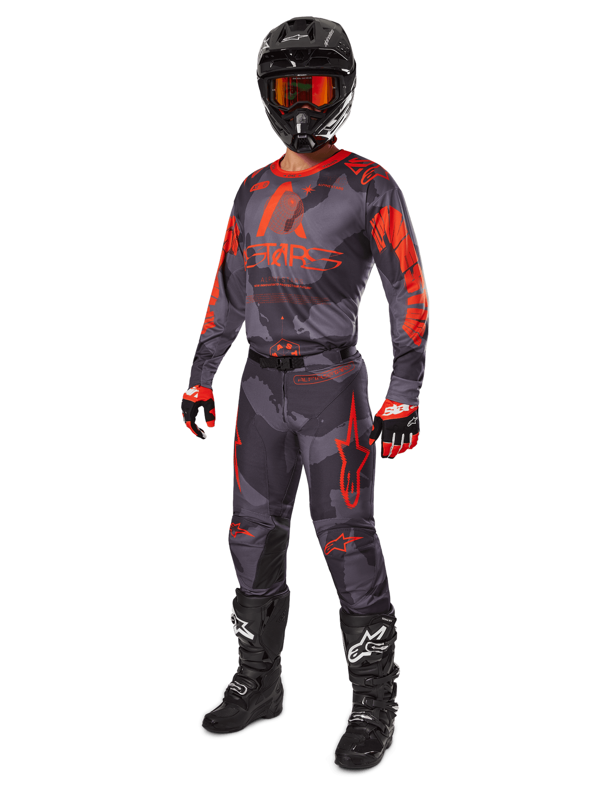 Motocross rider wearing complete racing gear, Alpinestars 2025 Racer Hollow Jersey and Pants in Gray Camo Orange Fluo, black helmet with orange goggles, black and red gloves, and black boots with white logos, coordinated performance outfit for off-road racing
