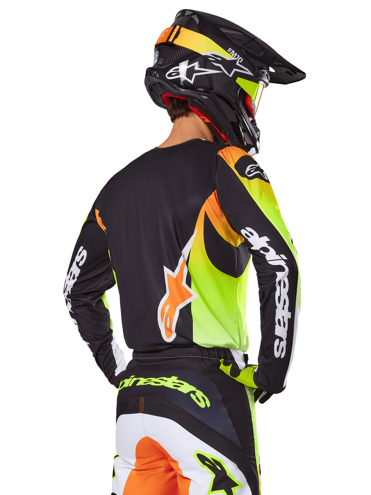 Motocross rider from behind wearing the Alpinestars 2025 Fluid Wurx Gear Set, black jersey with vibrant neon yellow and orange graphics, matching pants with white and orange panels, black helmet with neon accents, bold Alpinestars branding on sleeves and seat