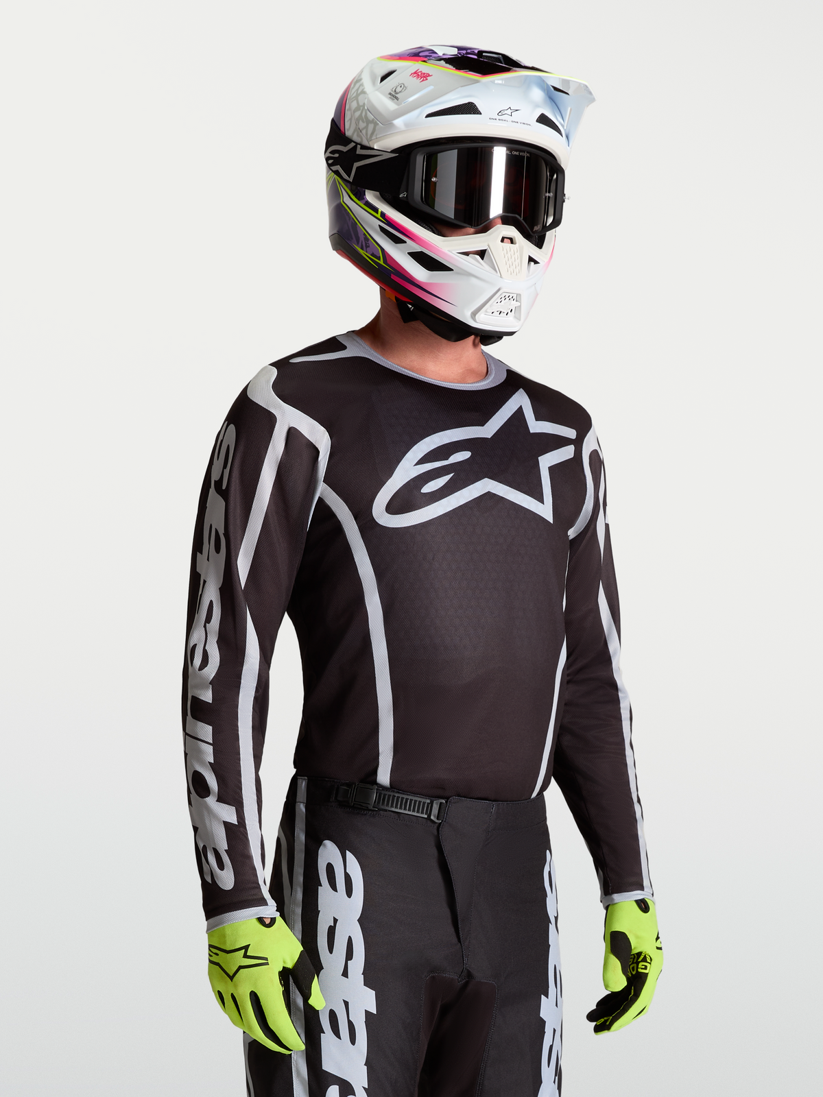 Alpinestars maillot Fluid Apex V2, maillot de motocross pour homme, noir et argenté, poly-tissu respirant, porté par un mannequin avec casque et gants