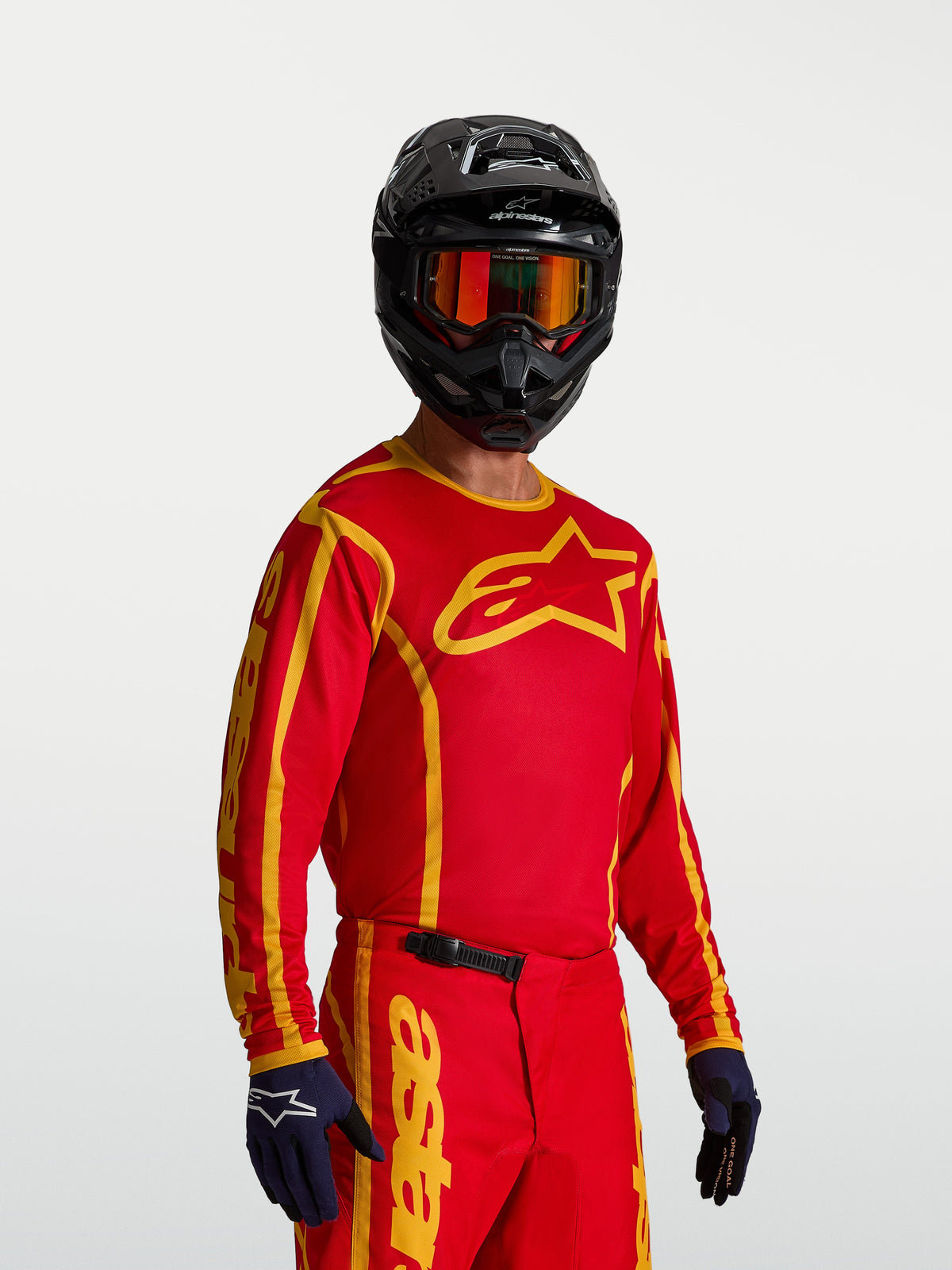 Alpinestars maillot Fluid Apex V2, maillot de motocross pour homme, rouge et doré, poly-tissu respirant, sur mannequin.