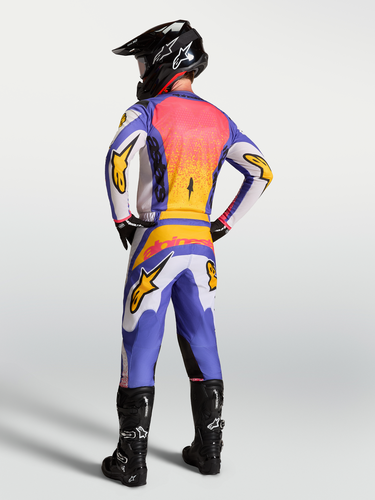 Alpinestars Fluid Drag, maillot et pantalon de motocross pour homme, bleu et lilas avec doré iris, vue de dos sur mannequin.