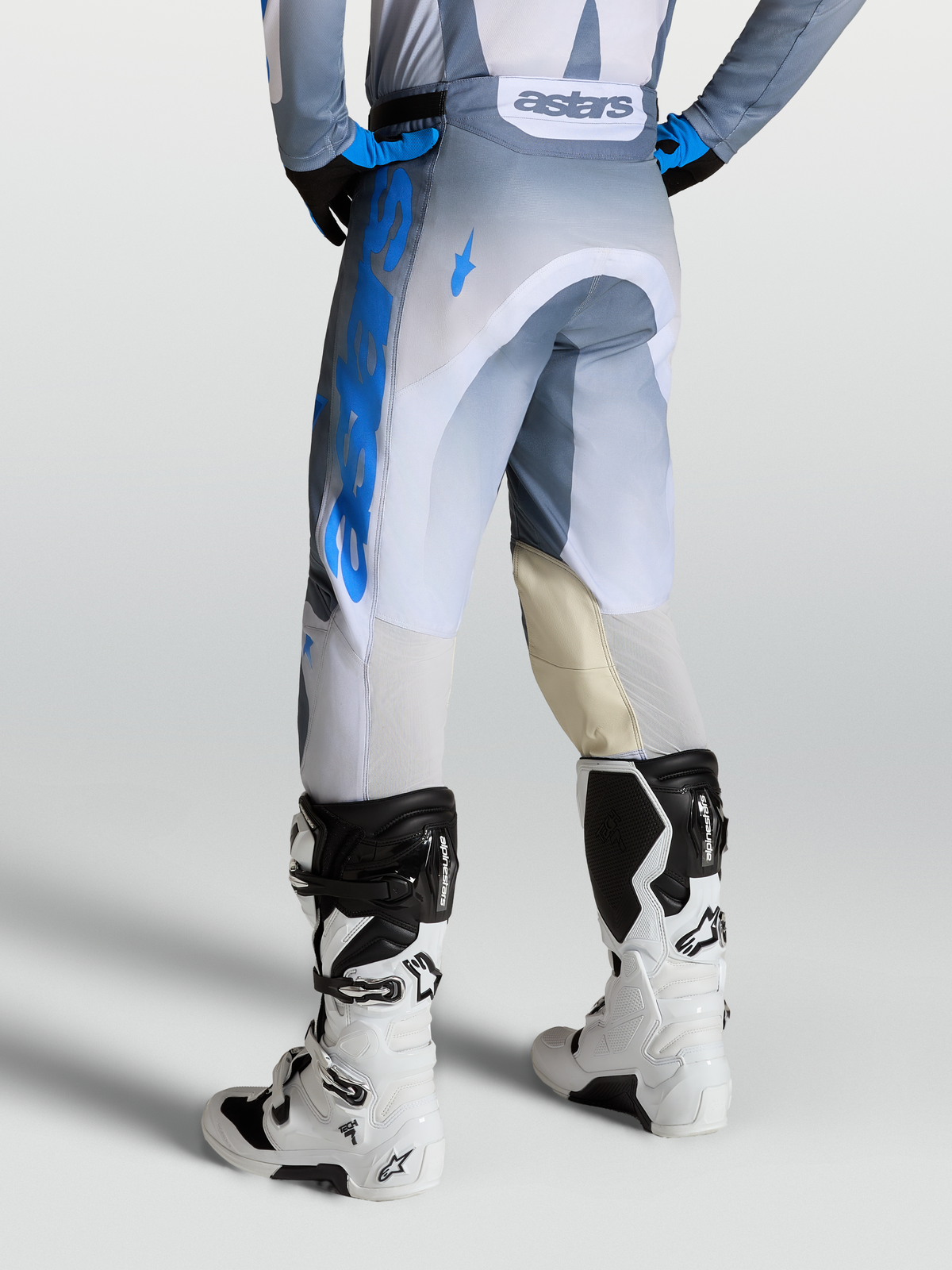 Alpinestars Pantalon Racer Amber, pantalon de motocross pour homme, gris et bleu, avec panneaux en cuir et ventilation arrière, vue de dos sur mannequin.