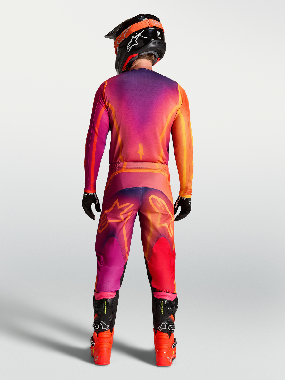 Pantalon Fluid Kepler Alpinestars violet et orange, vue de dos sur mannequin avec maillot, tenue de motocross tout-terrain.