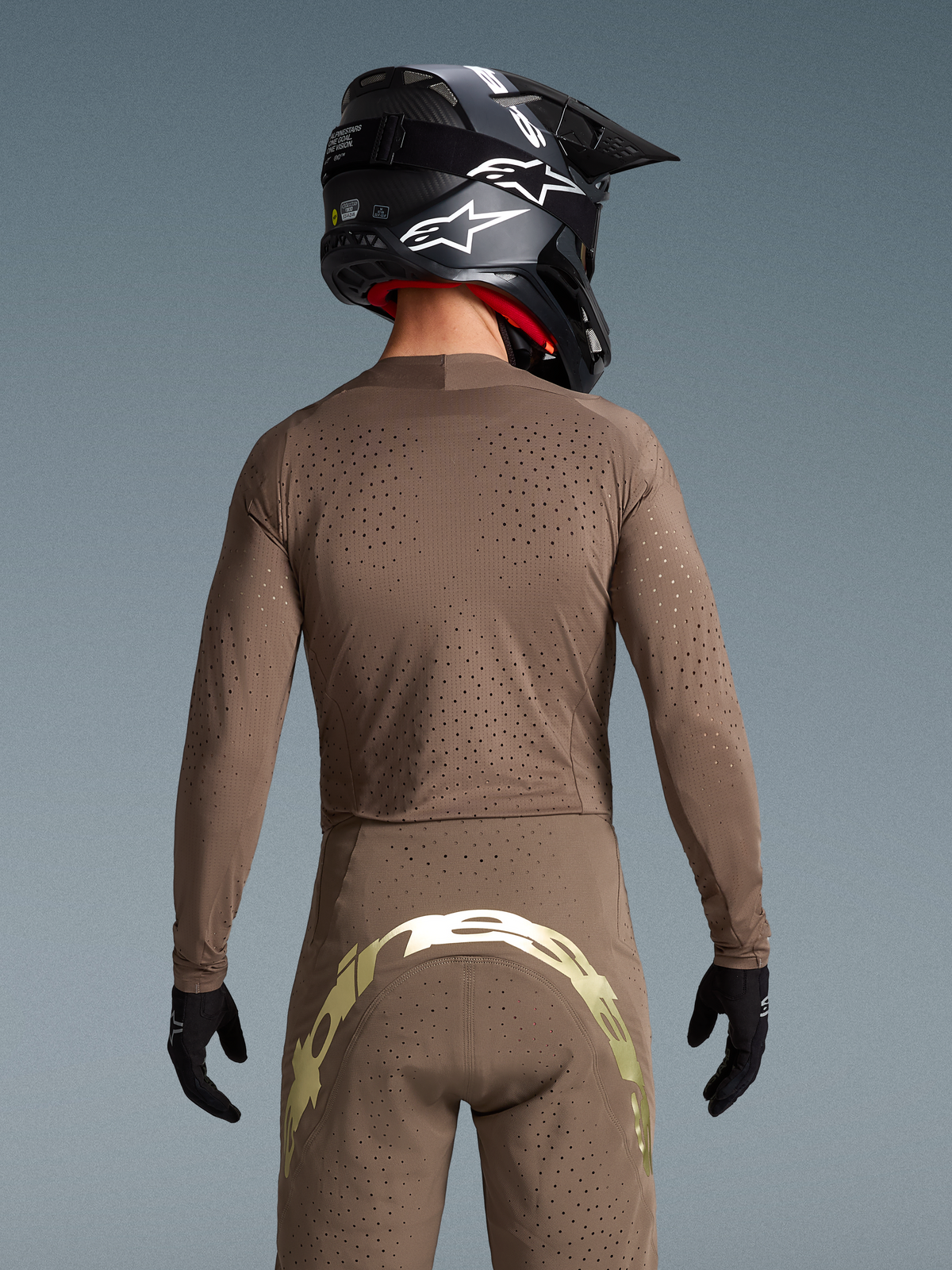 Tenue Alpinestars Supertech Air Gold Édition Limitée, marron et dorée, motocross, vue de dos, ventilation découpée au laser.