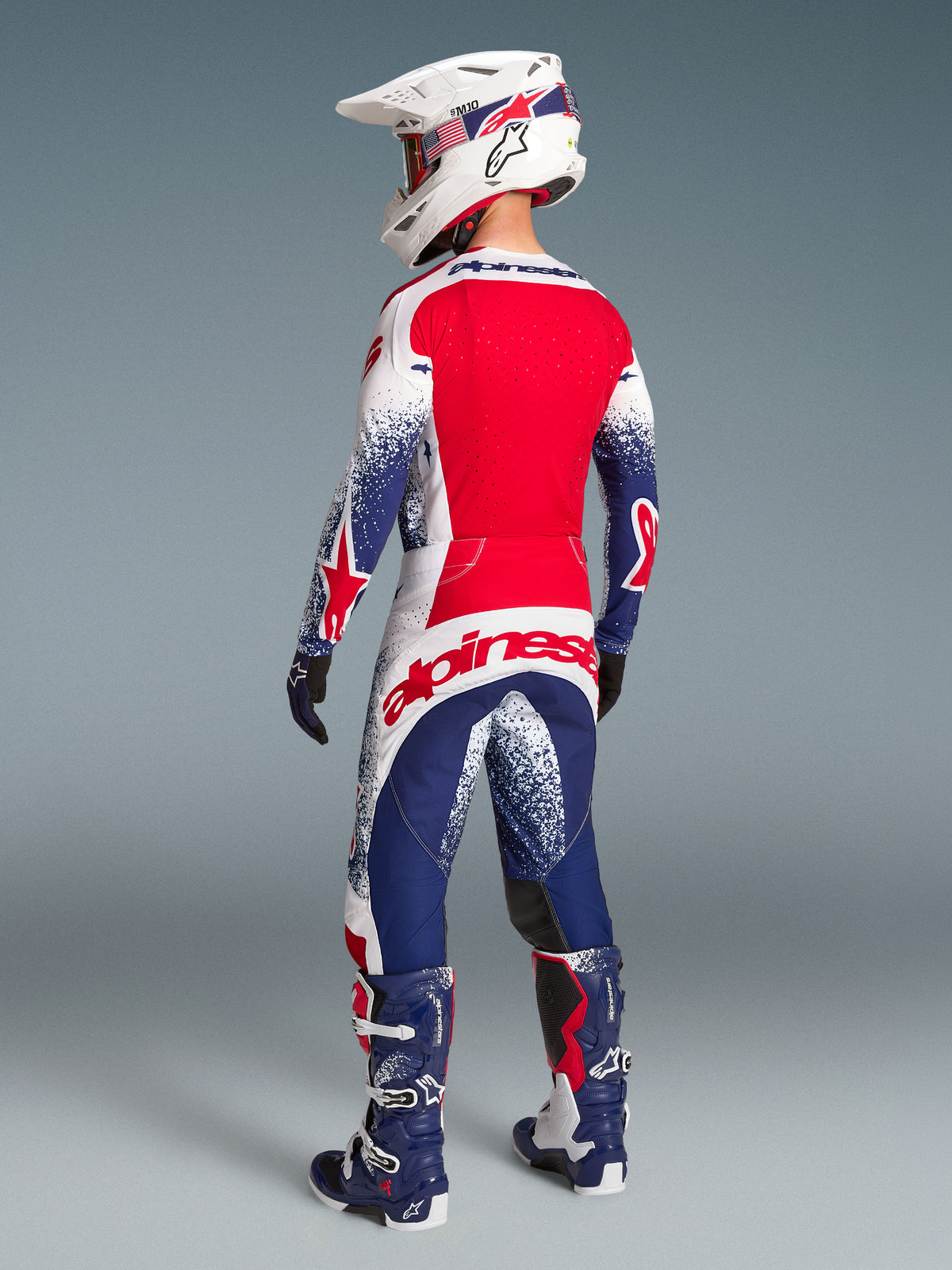 Alpinestars Techstar Unity, maillot de motocross rouge, blanc et bleu, édition limitée, panneaux ventilés, vue de dos.