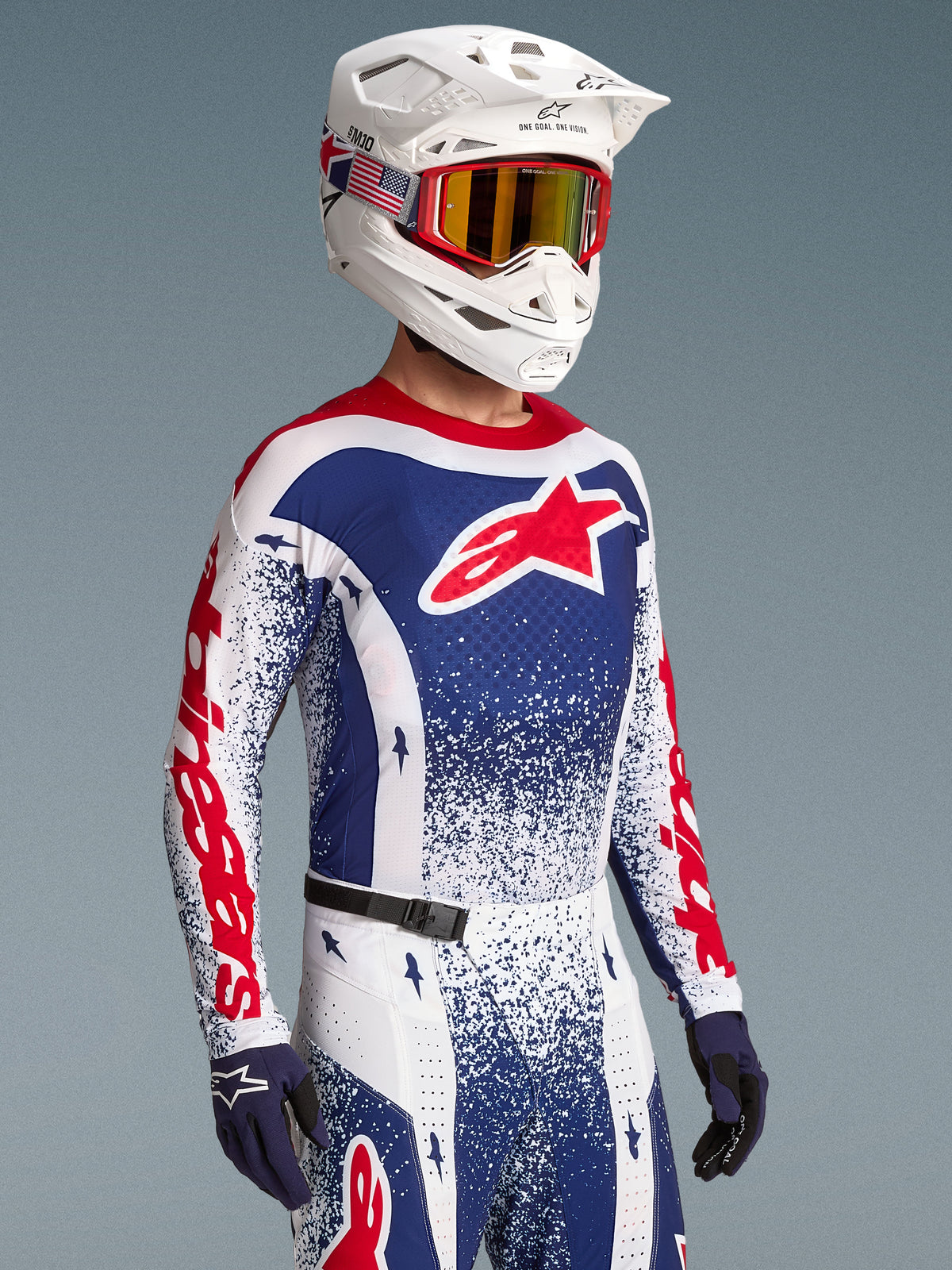 Maillot Alpinestars Techstar Unity, maillot de motocross édition limitée pour homme, bleu, blanc et rouge à motif éclaboussures, porté par un pilote