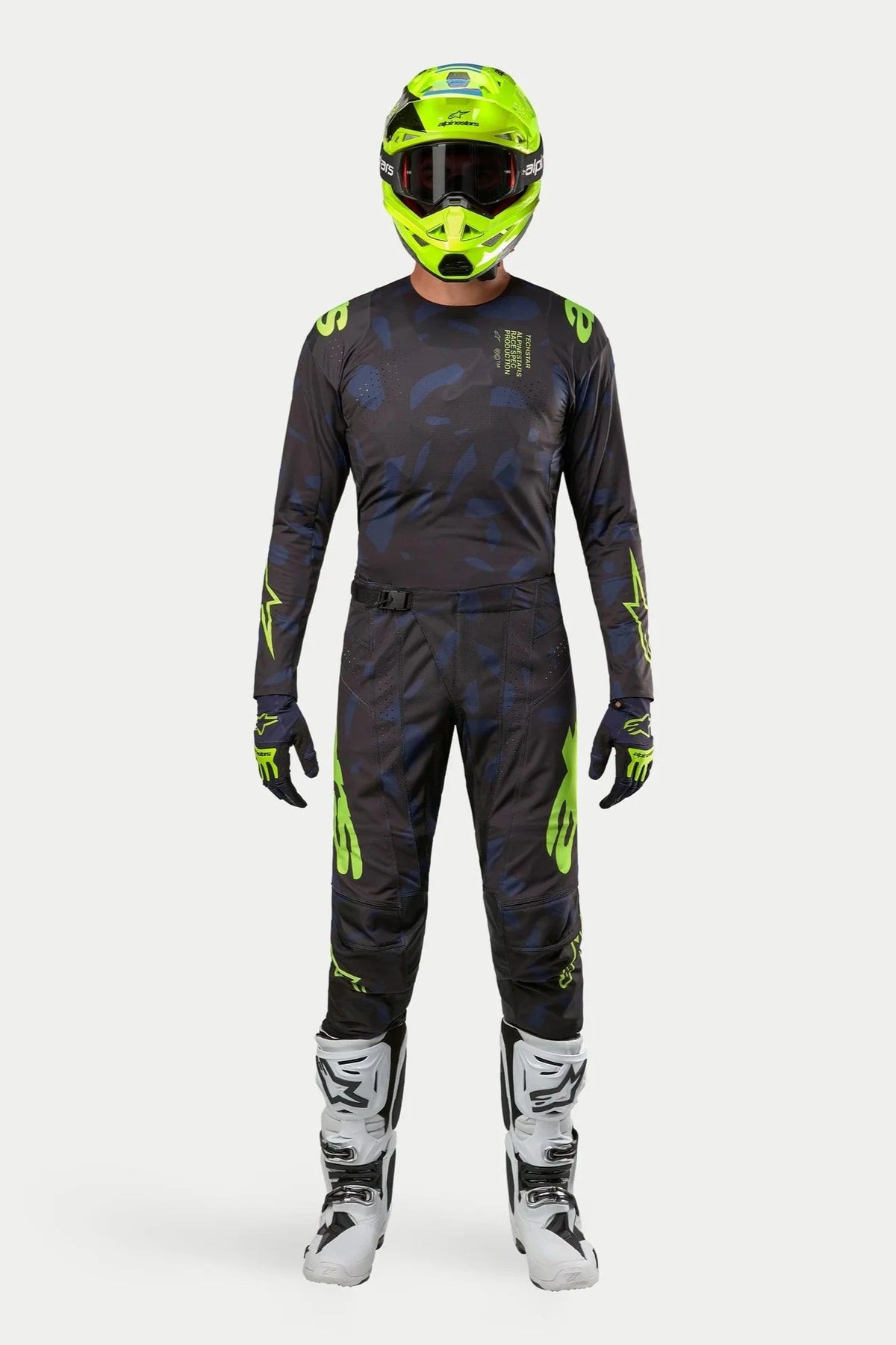 Ensemble maillot et pantalon Alpinestars Techstar Rantera 2024, tenue de motocross, noir, bleu marine et jaune fluo, porté avec un casque jaune fluo assorti et des bottes blanches, avec logos jaunes vifs et panneaux en maille technique pour la performance tout-terrain