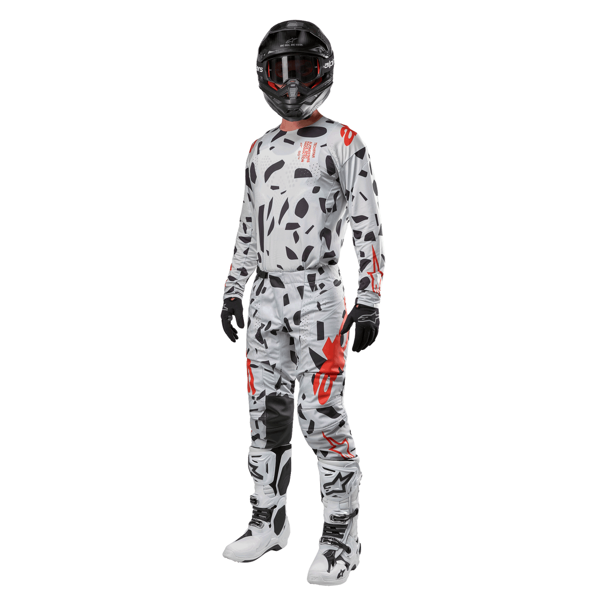Pilote de motocross portant le maillot Alpinestars Techstar Rantera 2024 en Haze Gray Camo, pantalon assorti avec accents rouges et noirs, casque et masque noirs, gants noirs, bottes blanches et noires, tenue de motocross complète et coordonnée pour la performance tout-terrain