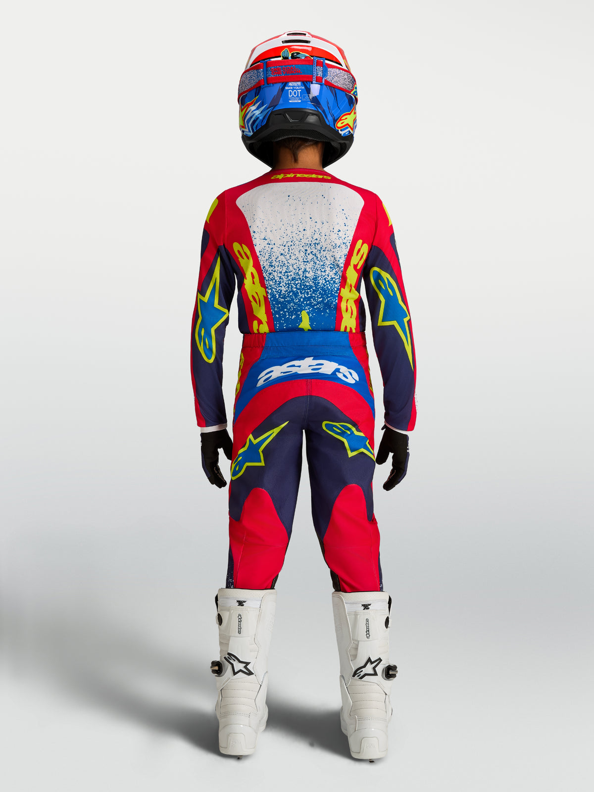 Alpinestars maillot et ensemble d'équipement Fluid Drag Junior 2027, tenue de motocross junior, bleu marine et rouge feu, vue de dos sur pilote.