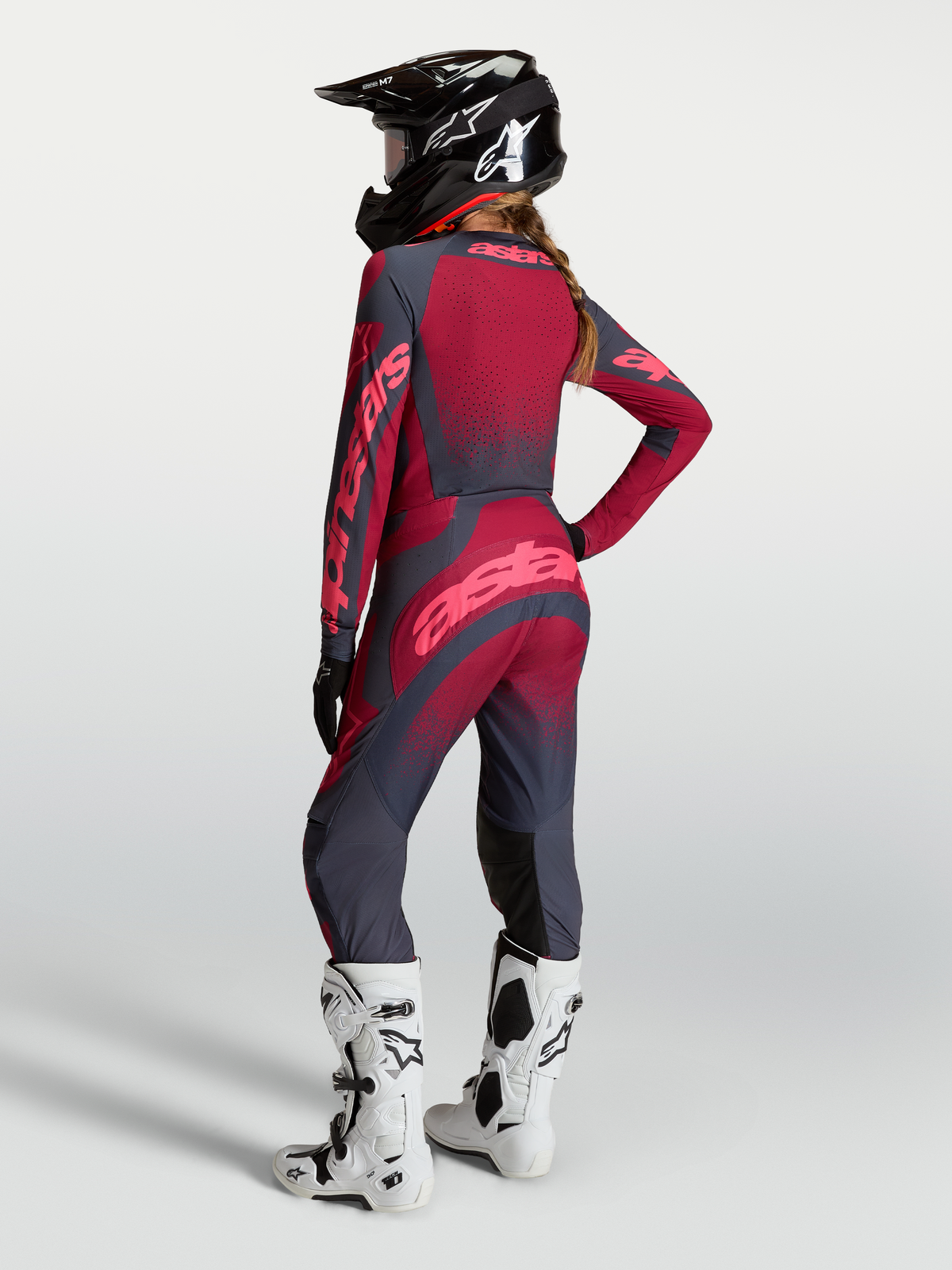 Pantalon Stella Techstar Swan, équipement de motocross pour femme, rouge et gris foncé, construction extensible durable, porté par une pilote avec casque et bottes