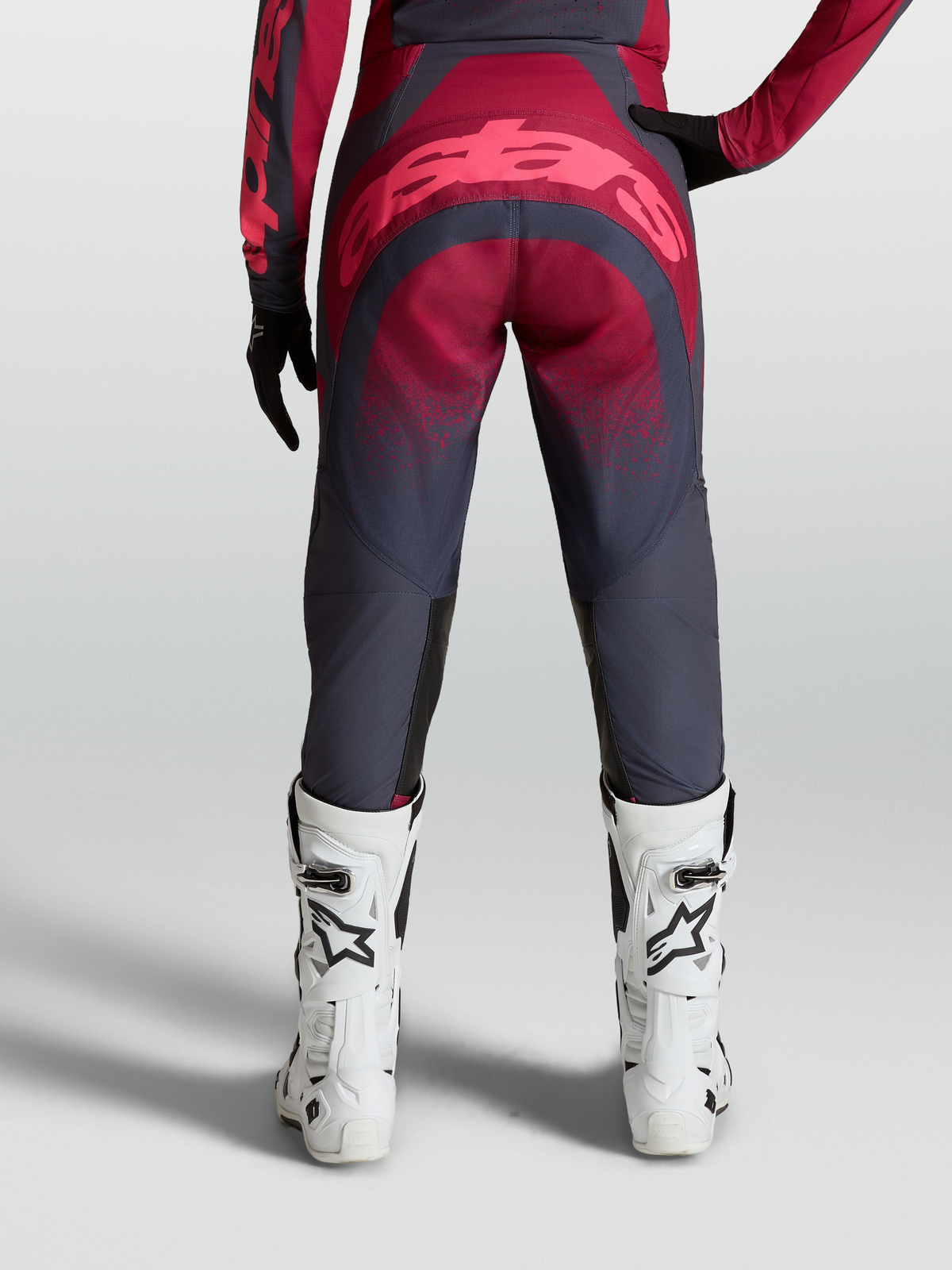 Alpinestars Pantalon Stella Techstar Swan, équipement de motocross pour femme, rouge cramoisi et gris anthracite, vue arrière sur mannequin avec bottes racing blanches.