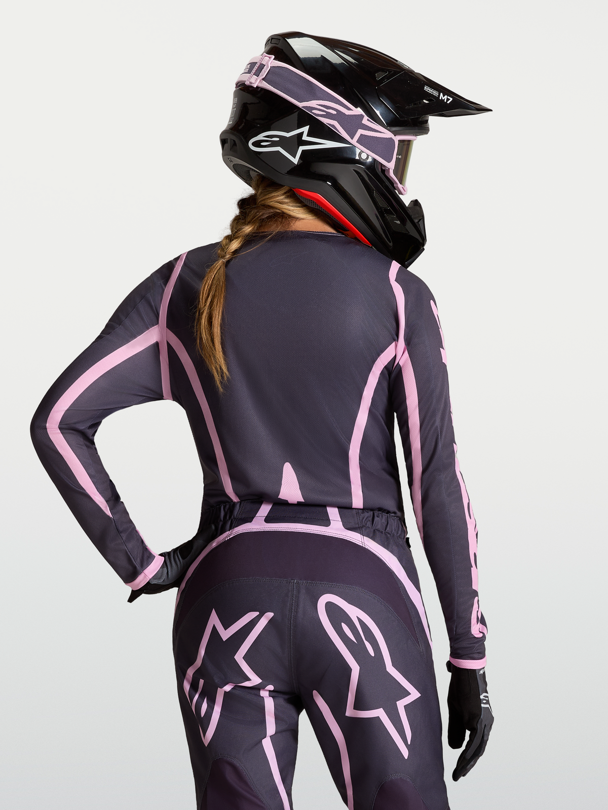 Maillot Stella Fluid Apex V2, équipement de motocross Alpinestars pour femme, gris et rose, porté avec casque assorti