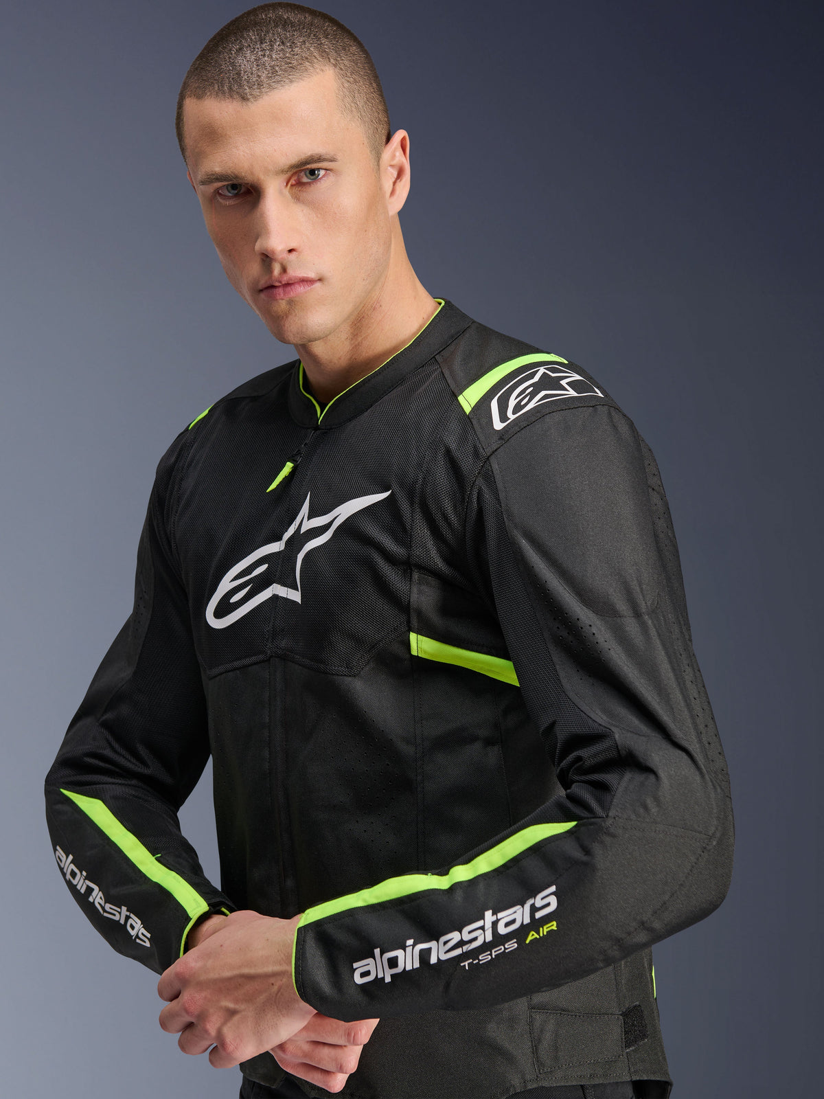 Veste Alpinestars T-Sps Air V2, Noir Jaune Fluo, veste de moto en textile portée par un mannequin, dotée de panneaux en mesh technique pour la circulation de l'air, logo Alpinestars blanc sur la poitrine et accents jaune fluo sur les épaules et les manches.