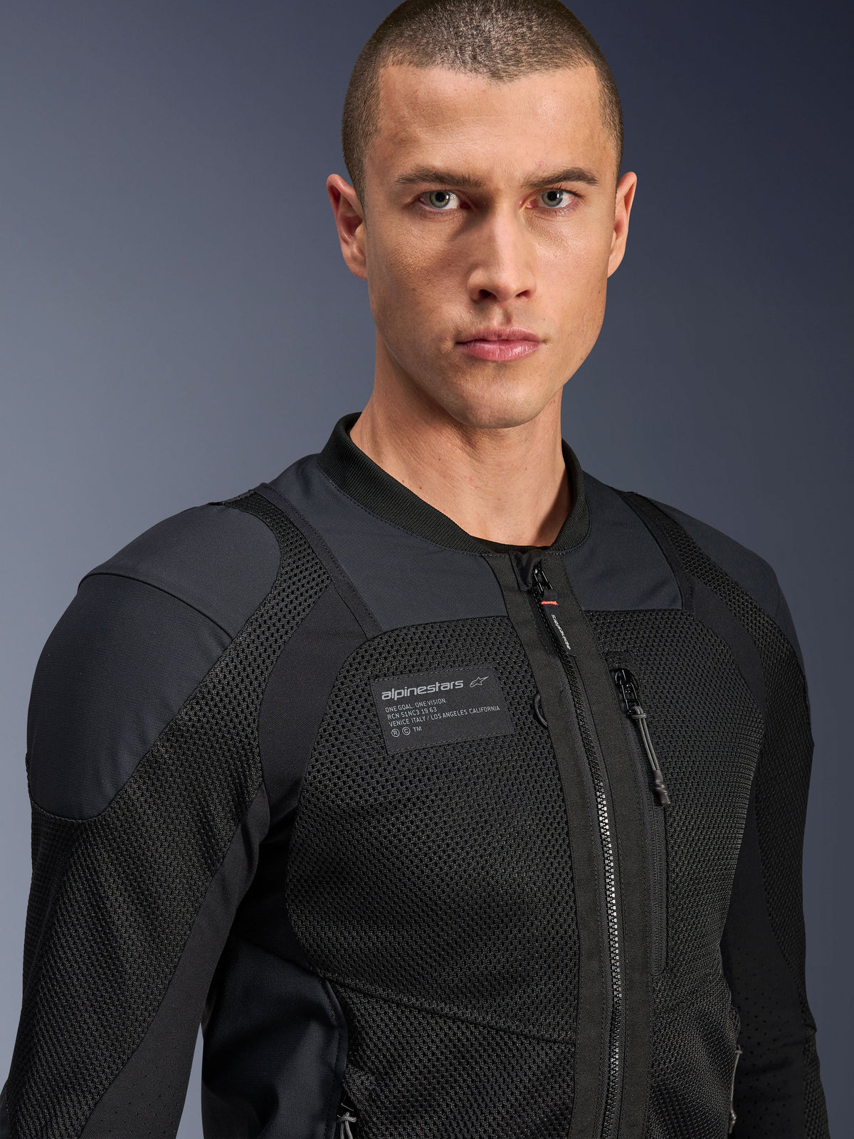 Alpinestars Troop-Air Pro Jacket, Black, technical armored air jacket for motorcycle riding, close-up portrait showing 2D mesh texture and chest branding patch.