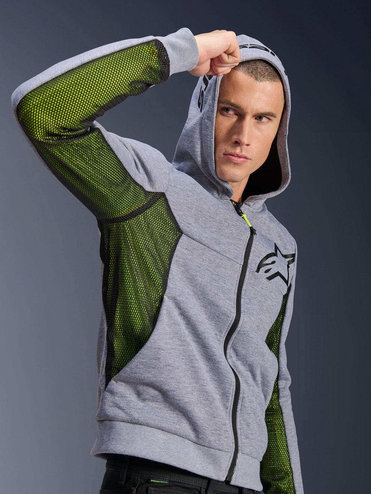 Alpinestars Chrome Air Sport Hoodie, gris chiné et noir, avec panneaux d'aération en maille vert vif sur les côtés et sous les manches, polaire technique avec capuche, logo Alpinestars noir sur la poitrine, vêtement de moto urbain