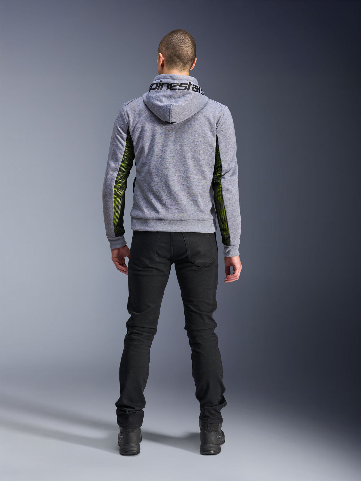 Alpinestars Chrome Air Sport Hoodie, Gris Chiné Noir, vue arrière d'un sweat à capuche de moto avec des panneaux en mesh vert sur les côtés et les manches, construction en polaire technique avec marquage Alpinestars sur la capuche, porté avec un pantalon noir