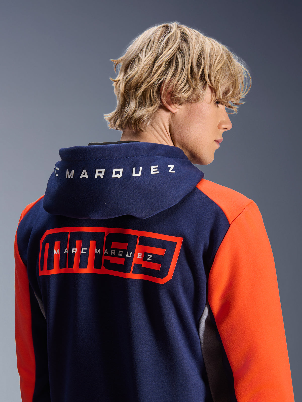 Alpinestars MM93 Chrome V2 Sport Hoodie, sweat à capuche de moto urbain, bleu marine avec manches orange vif, grand logo MM93 rouge et marquage Marc Marquez dans le dos, lettrage blanc sur la capuche, style décontracté