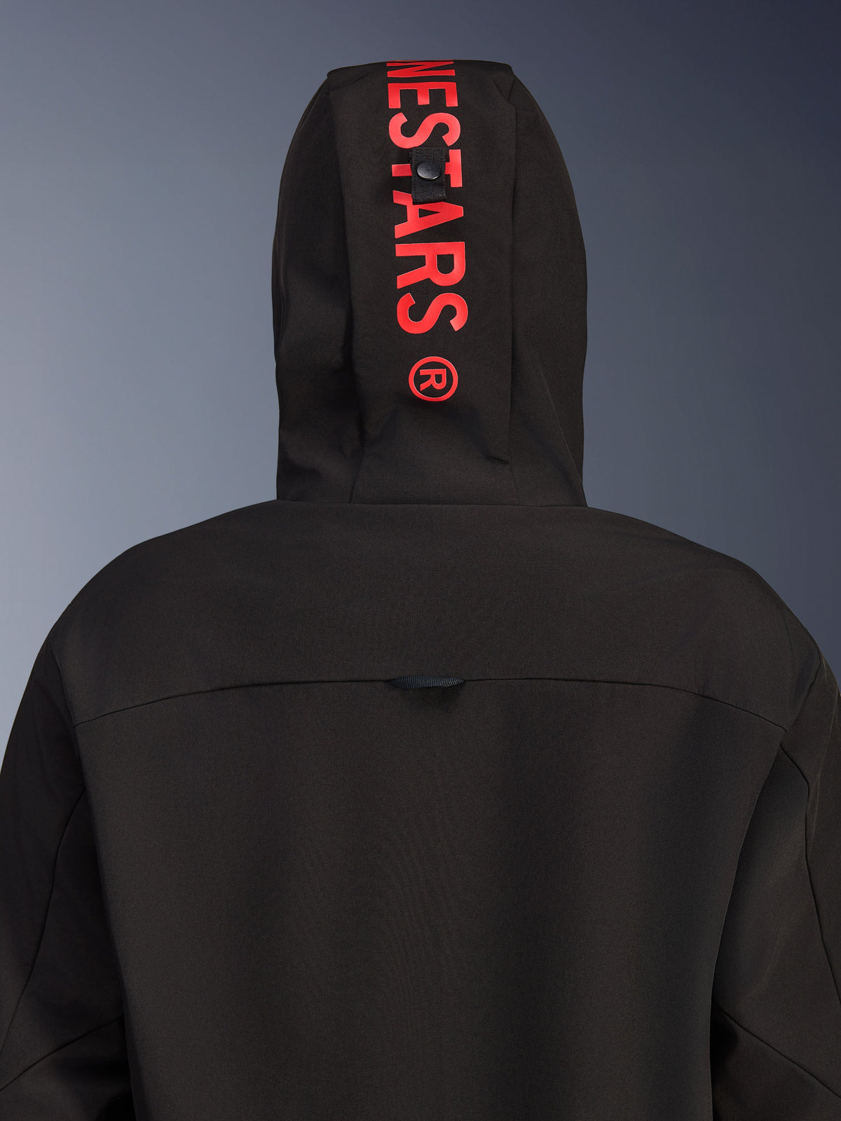 Alpinestars Radium Tech Hoodie, veste de moto urbaine, noir avec rouge vif, vue arrière centrée sur la capuche avec logo rouge vertical, coque textile coupe-vent et design contemporain.