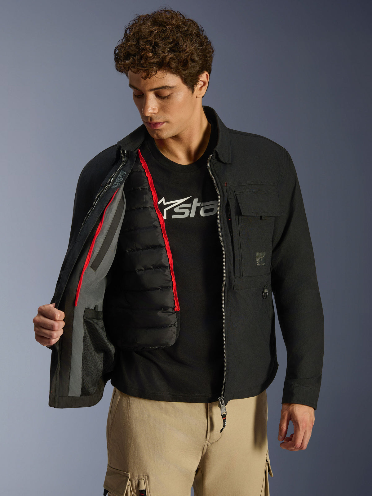 Alpinestars Bryon WR Overshirt, Black, urban motorcycle jacket shown open to reveal a detachable black quilted thermal vest with red trim, worn with tan cargo pants and a logo tee, functional workwear-inspired design