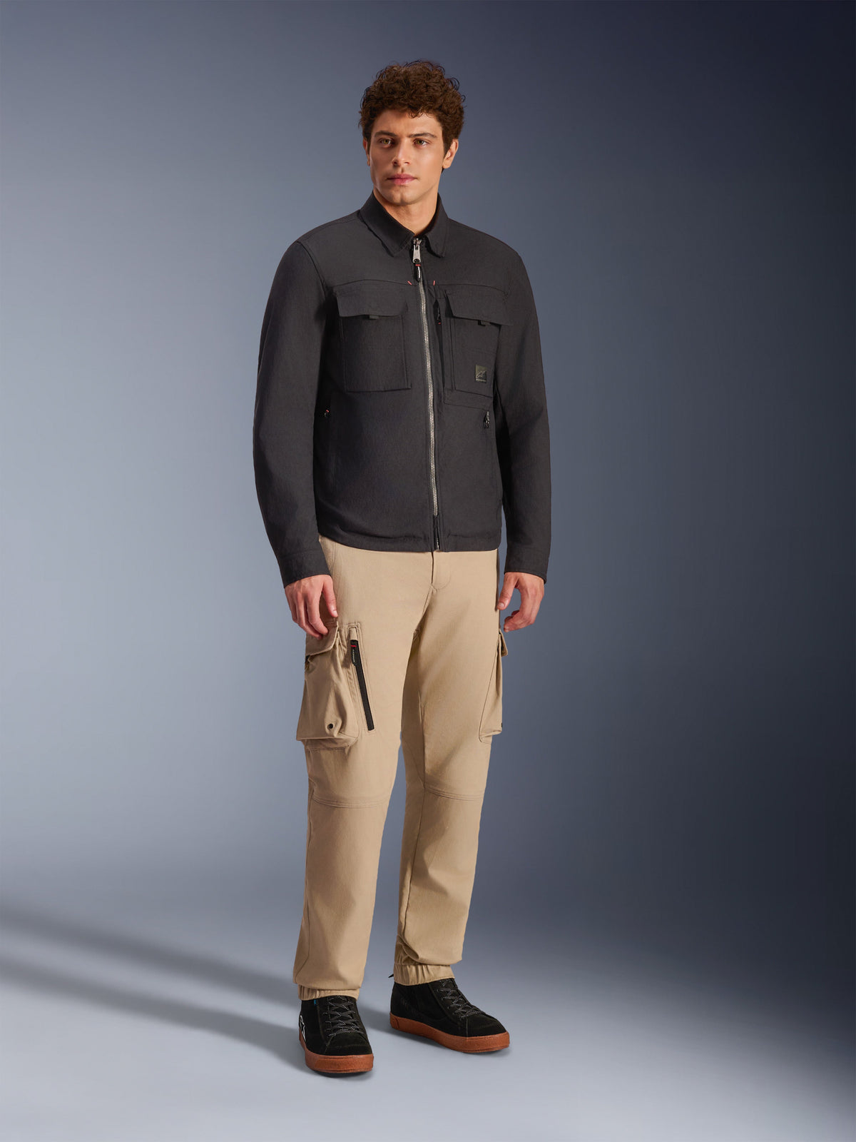 Alpinestars Bryon Water Resistant Overshirt, Black, worn by male model with khaki cargo pants and black shoes, urban motorcycle jacket with workwear-inspired design, full-length studio shot