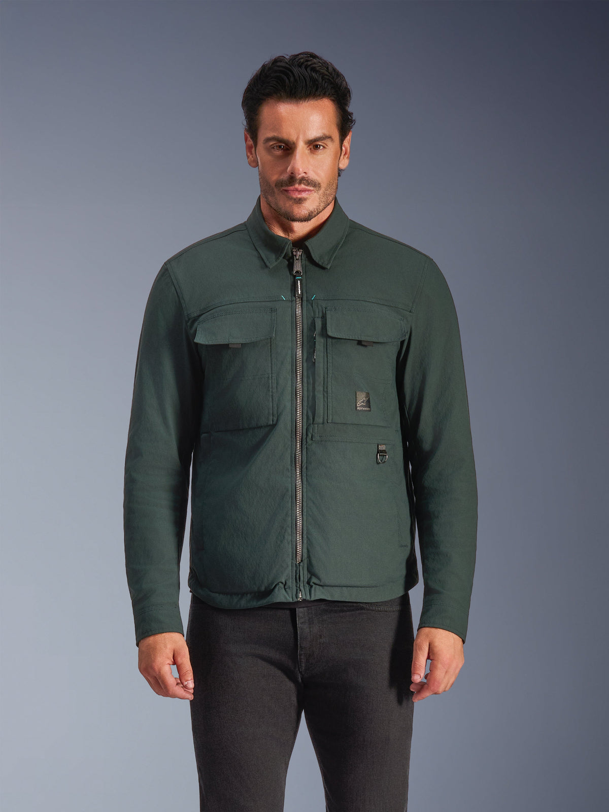 Alpinestars Bryon Water Resistant Overshirt, Dark Emerald, Men's Urban Riding Jacket, Male model wearing dark green overshirt with front zipper and large chest cargo pockets, water-resistant waxed canvas for motorcycle road riding