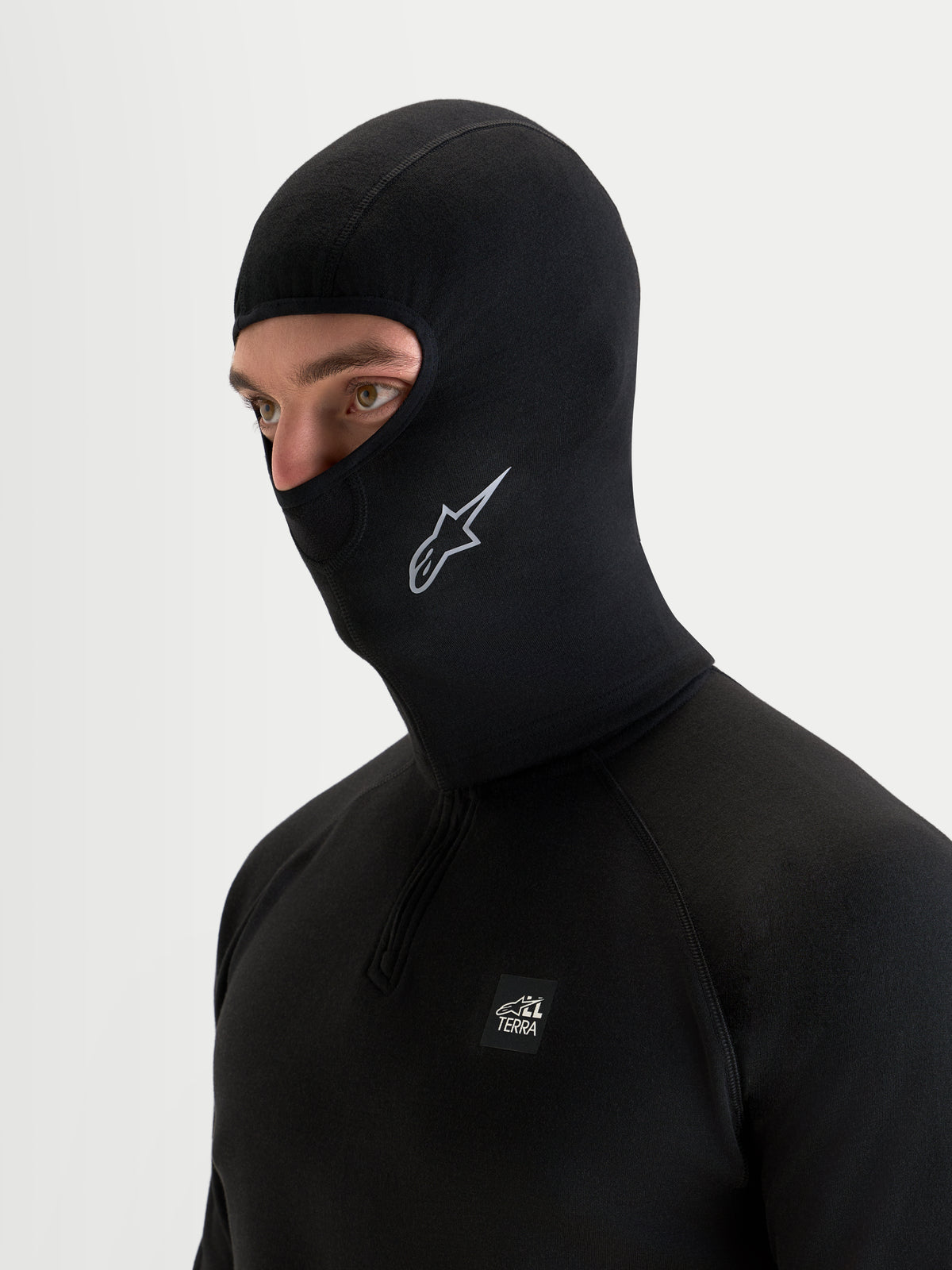 Alpinestars At 8 Merino Cagoule, cagoule de moto noire en laine mérinos avec couverture prolongée du cou, portée par un modèle
