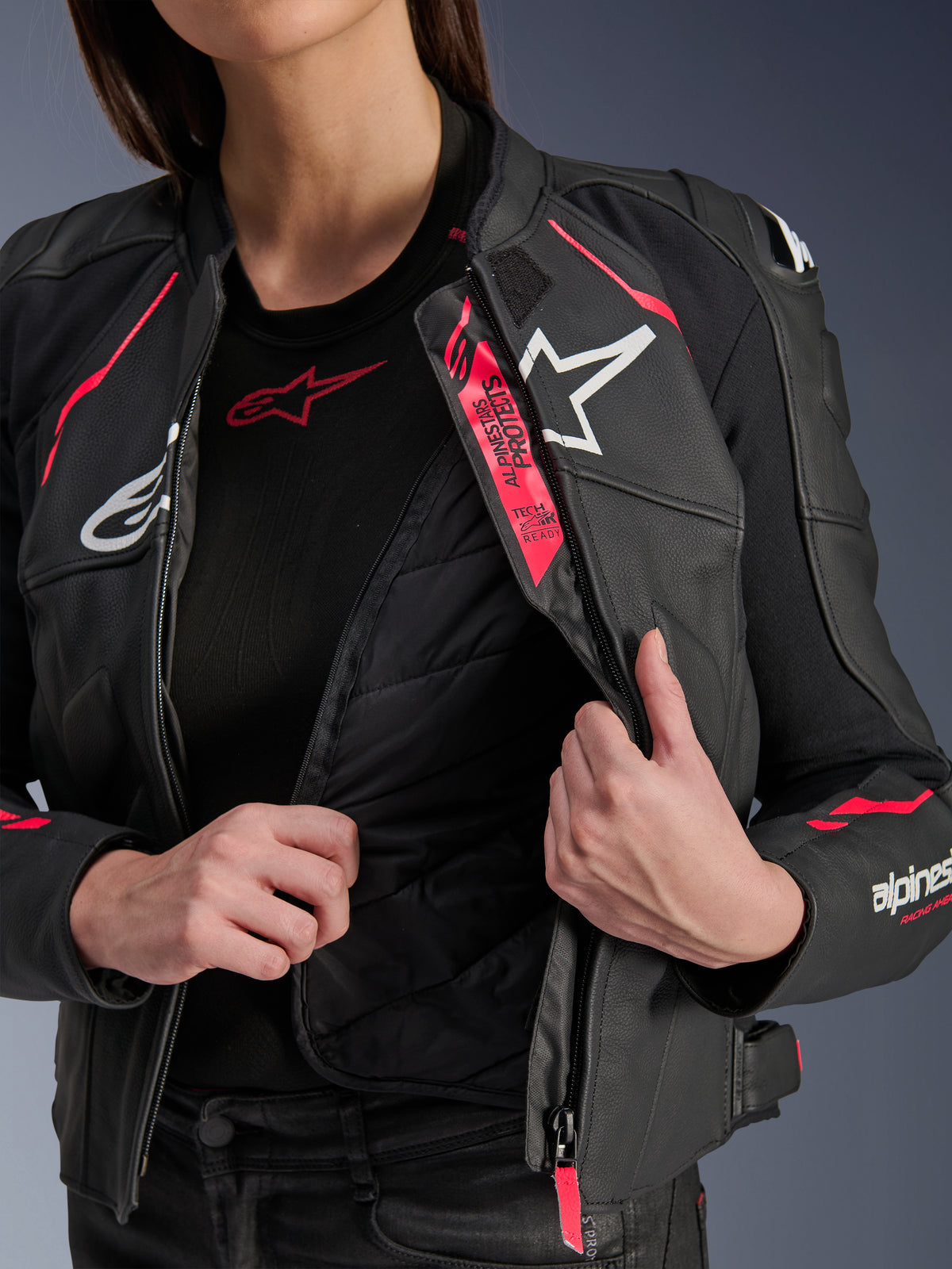 Veste en cuir Alpinestars Stella Dusk pour femme, noir, rose Diva et blanc, veste de moto en cuir ouverte pour laisser apparaître la doublure thermique matelassée et le marquage Tech-Air Ready, logos blancs et accents rose vif.