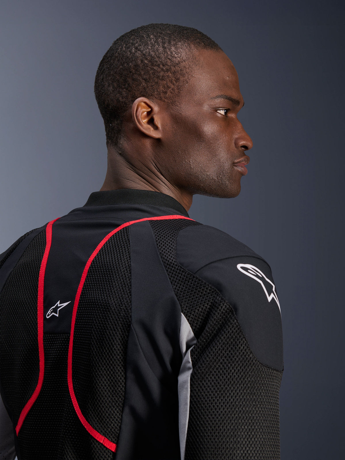 Veste Alpinestars Troop-Air Pro, veste technique ventilée avec protections, Noir, Gris Cendre et Rouge Vif, vue rapprochée de profil et de dos montrant les panneaux en textile mesh, les liserés rouges et les logos Astars blancs sur l'épaule et le haut du dos