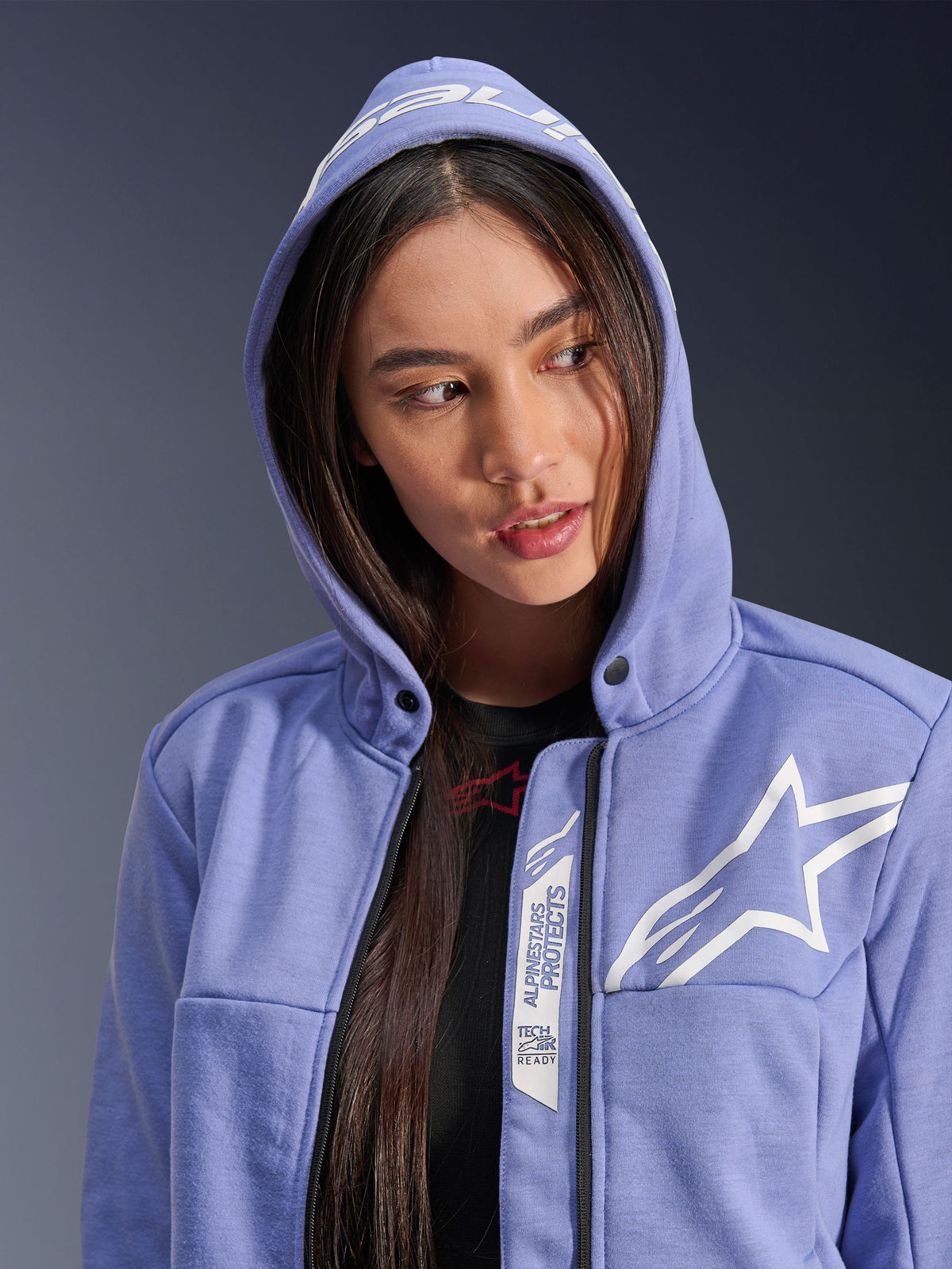 Sweat à capuche sport Alpinestars Stella Chrome V2, sweat à capuche de moto pour femme, bleu violet avec logo étoile blanc, détails « Alpinestars Protects » et « Tech-Air Ready » le long de la fermeture éclair, design urbain avec capuche relevée.