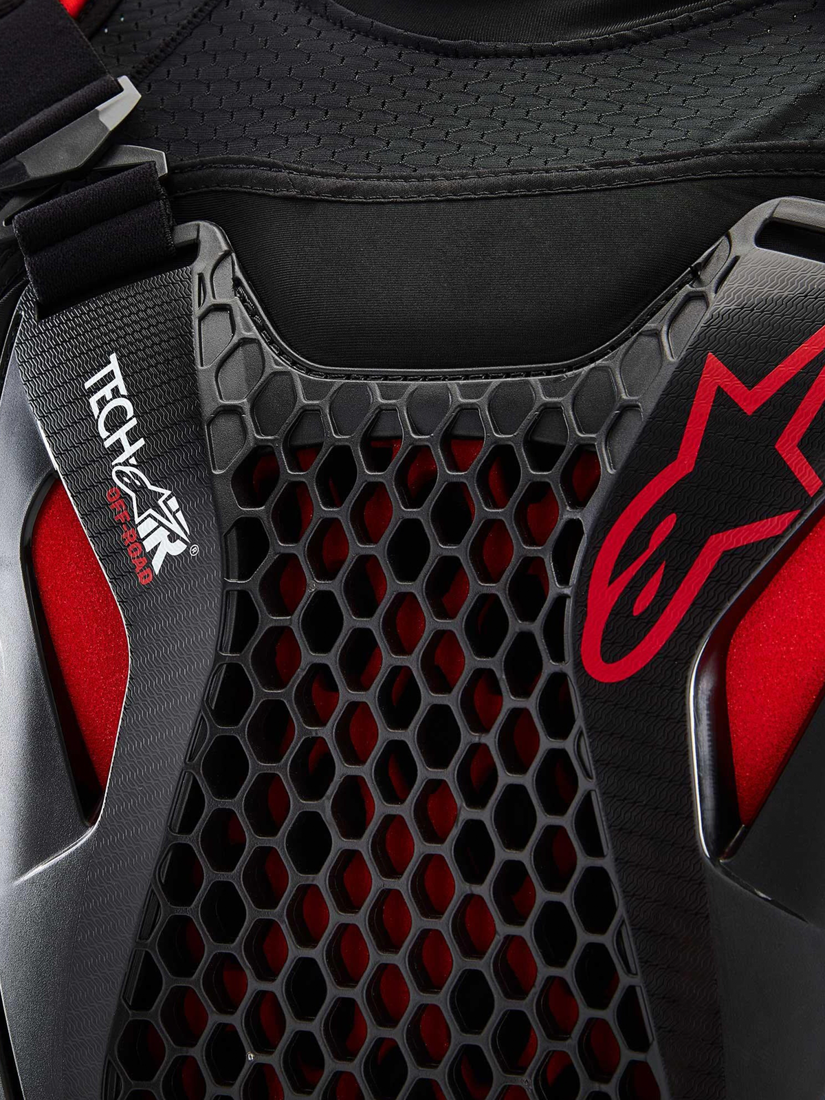 Système Airbag Tech-Air® Off-Road Alpinestars, détail en gros plan du système airbag moto tout-terrain, noir et rouge, avec protection de poitrine en nid d'abeille Nucleon CELL, marquage Tech-Air et châssis en mesh extensible respirant