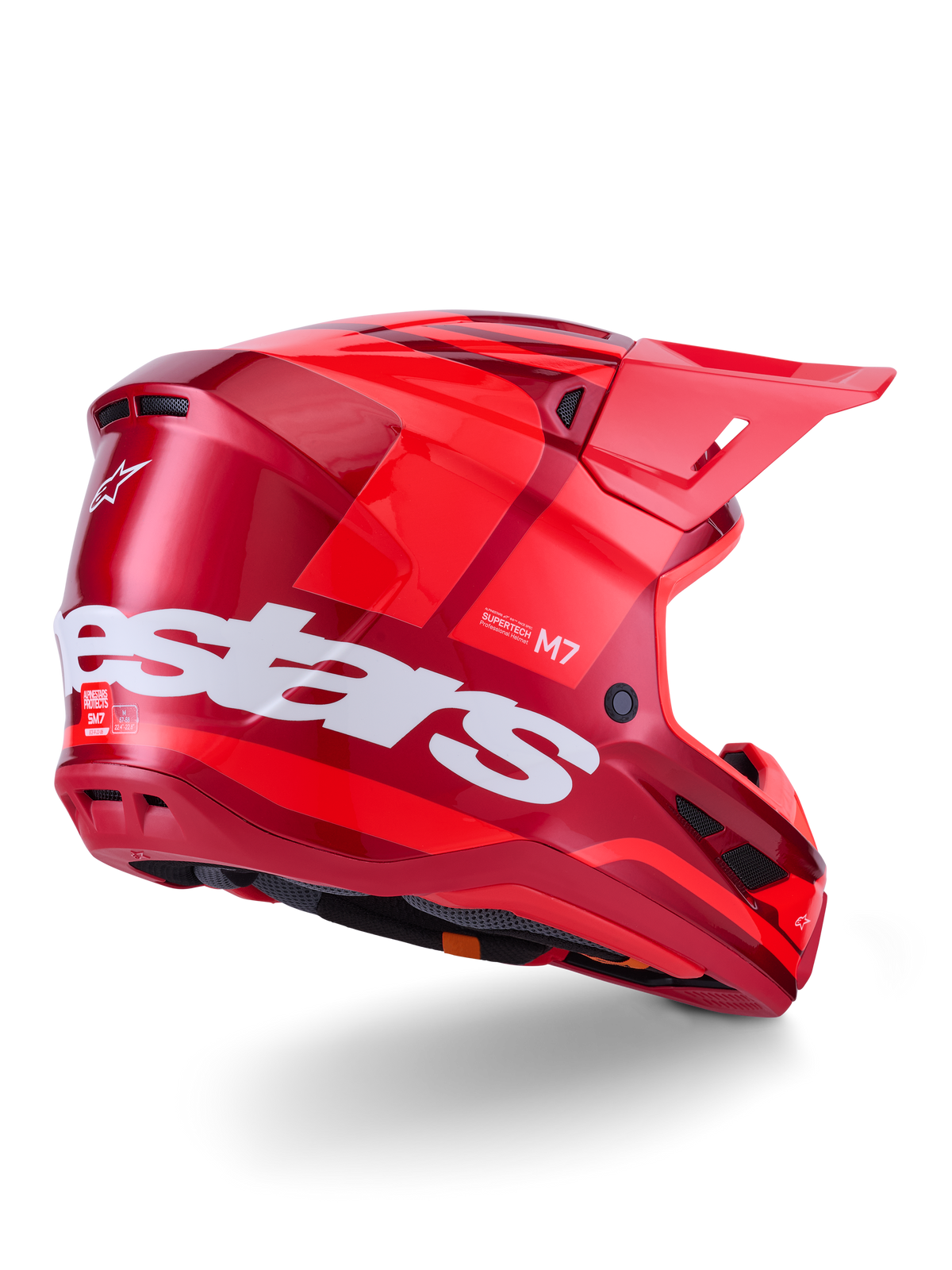 Casque Alpinestars S-M7 Core, casque de motocross, rouge brillant avec un grand logo Alpinestars blanc sur le côté, doté d'une coque aérodynamique, de ports de ventilation intégrés et d'une visière de protection, vue arrière 3/4