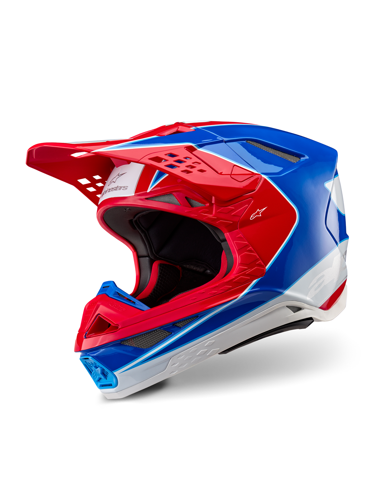 Casque Alpinestars Supertech M10 Aeon, casque de motocross, rouge et bleu brillant, vue de trois-quarts montrant la coque aérodynamique avec de multiples orifices de ventilation, accents graphiques blancs et rouges, logo Alpinestars sur la visière et le côté, équipement de course tout-terrain professionnel