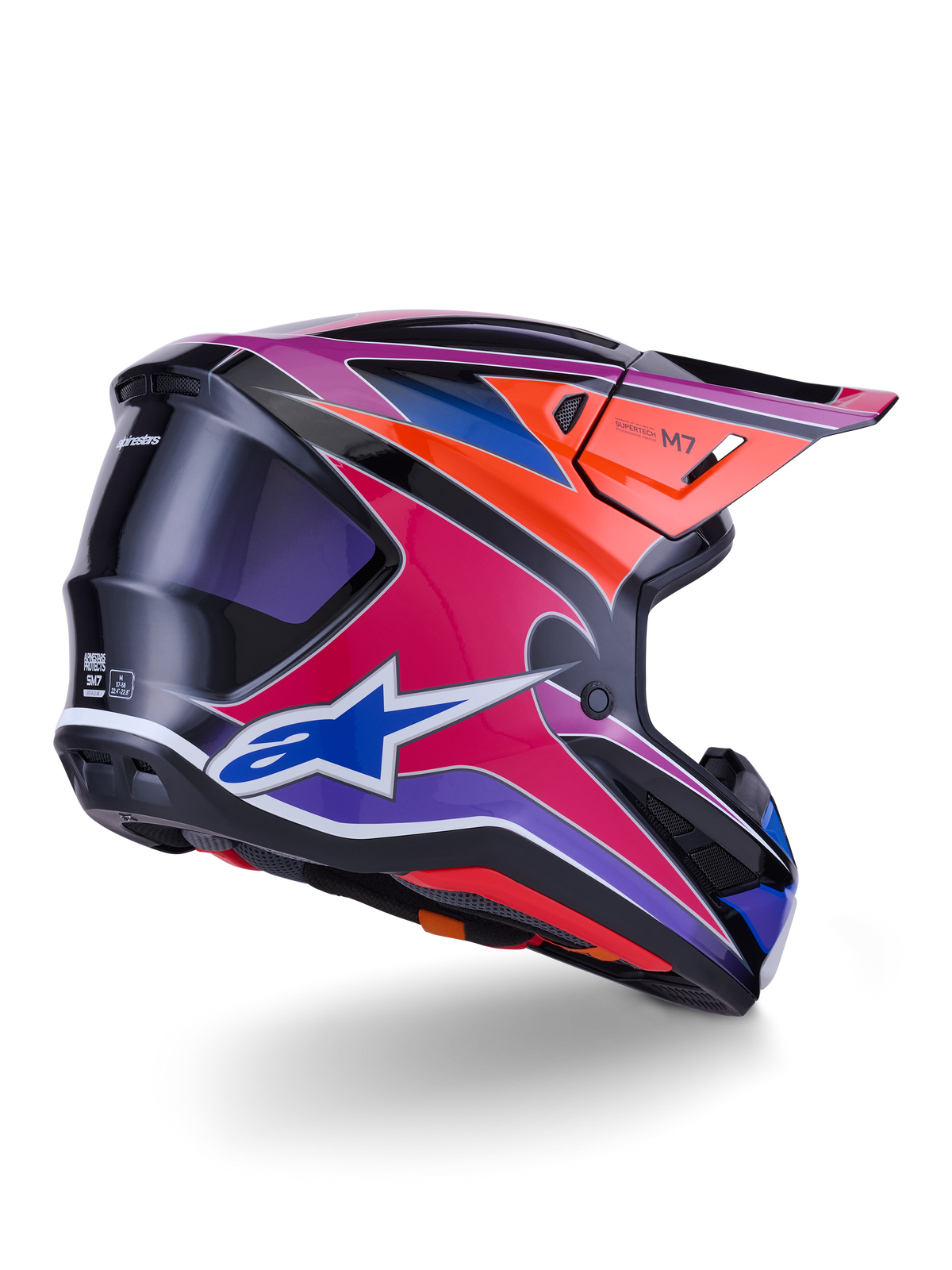 Casque Alpinestars S-M7 Fuse, casque de motocross, finition brillante bleu, violet et rose avec accents orange et noir, vue de trois-quarts arrière montrant la coque aérodynamique, la visière et les ports de ventilation, protection professionnelle pour la course tout-terrain