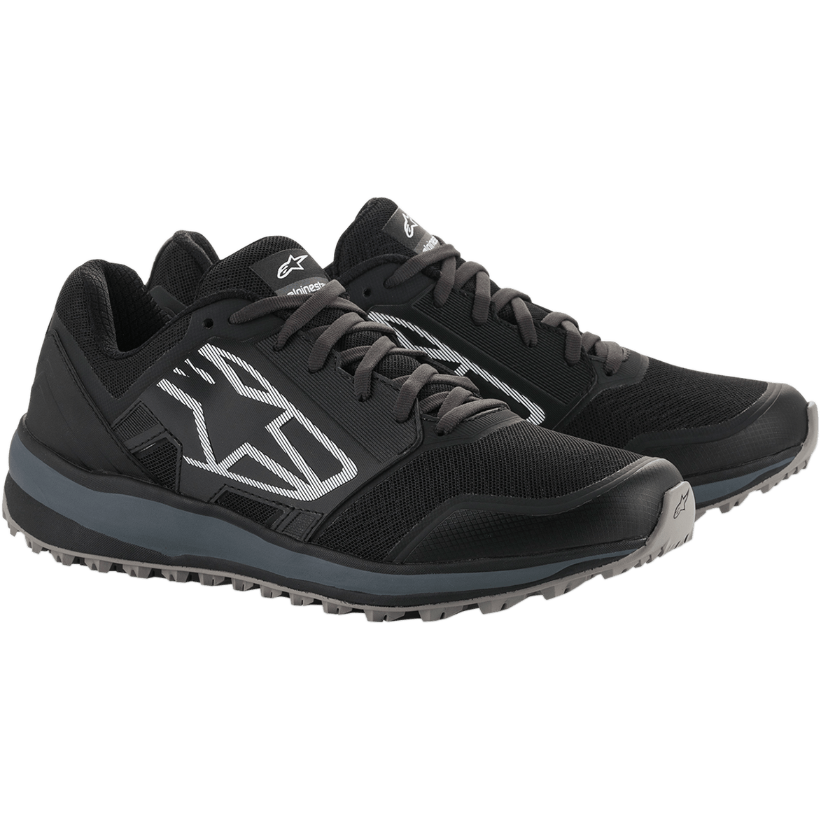 Chaussures Alpinestars Meta Trail, chaussures de course performantes, noir et gris foncé, grand logo Astars blanc rayé sur le côté, conception à lacets avec une semelle grise robuste, conçues pour un confort tout au long de la journée dans le paddock