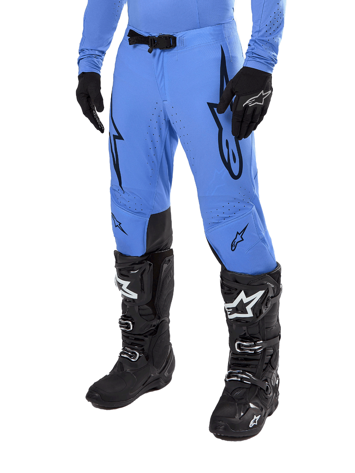 Alpinestars 2024 Supertech Dade Pants, pantalon de motocross, bleu clair avec logos graphiques noirs, avec perforations de ventilation et boucle magnétique à la taille, porté avec des bottes de pilotage techniques et des gants noirs, équipement de course tout-terrain professionnel